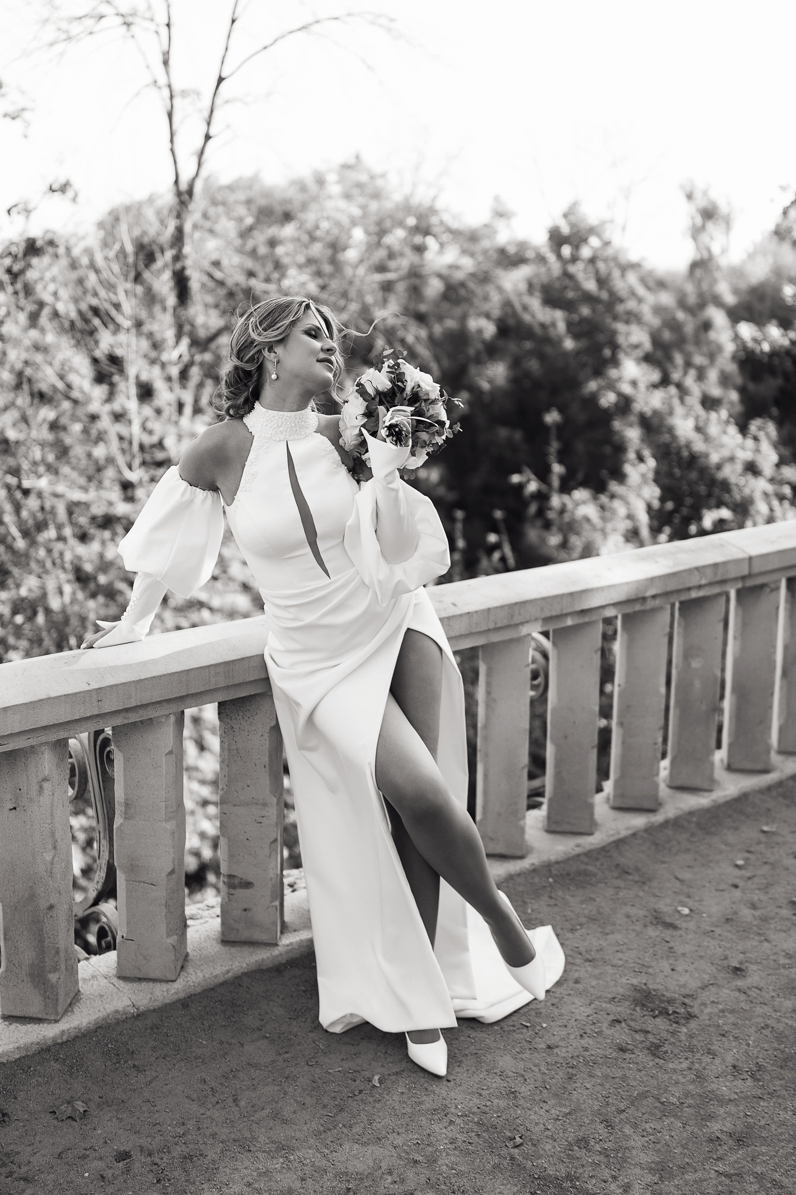 Невеста позирует с букетов у забора грота замка Ольденбургских