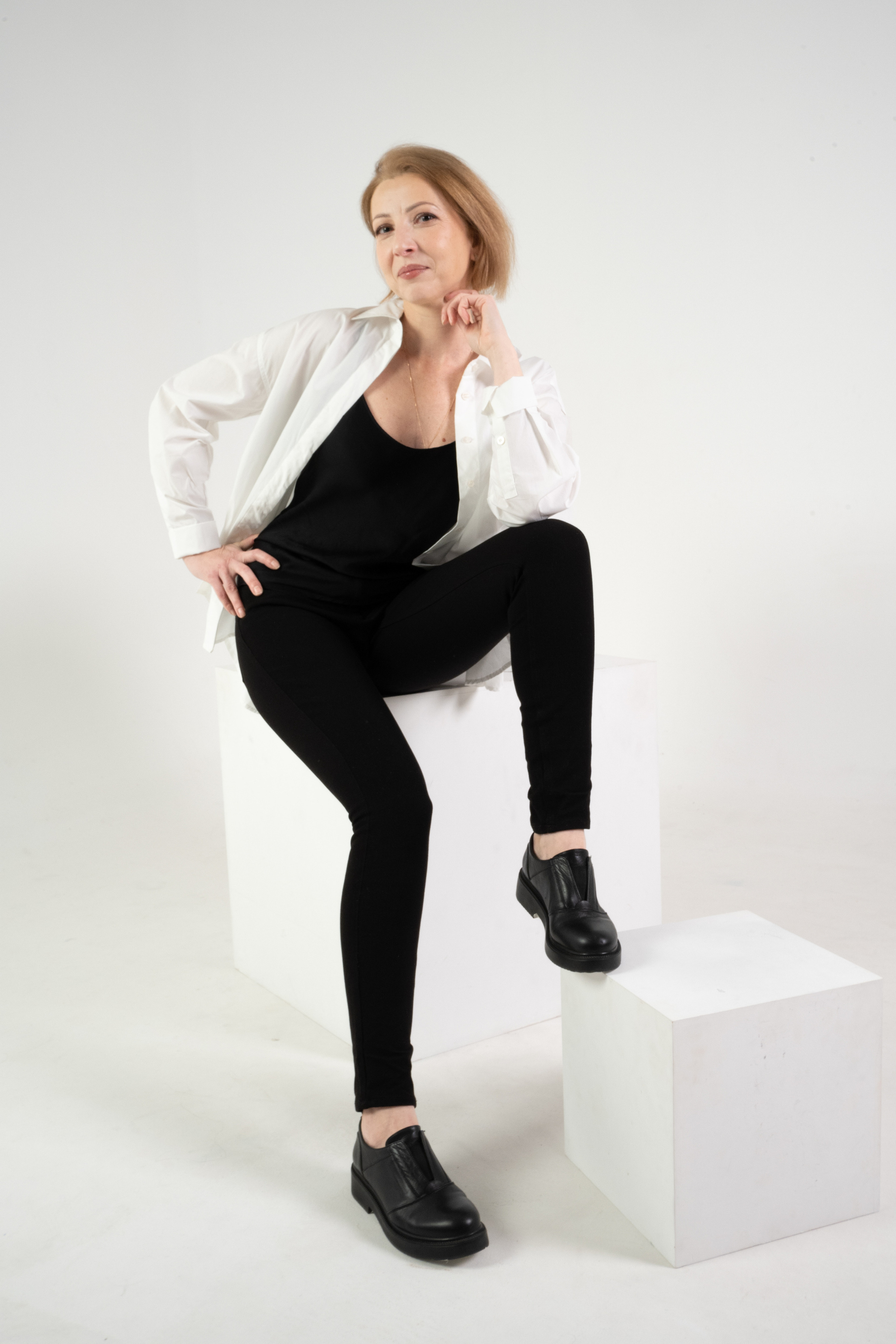 Фотосессия девушки средних лет на белом фоне с квадратными коробами