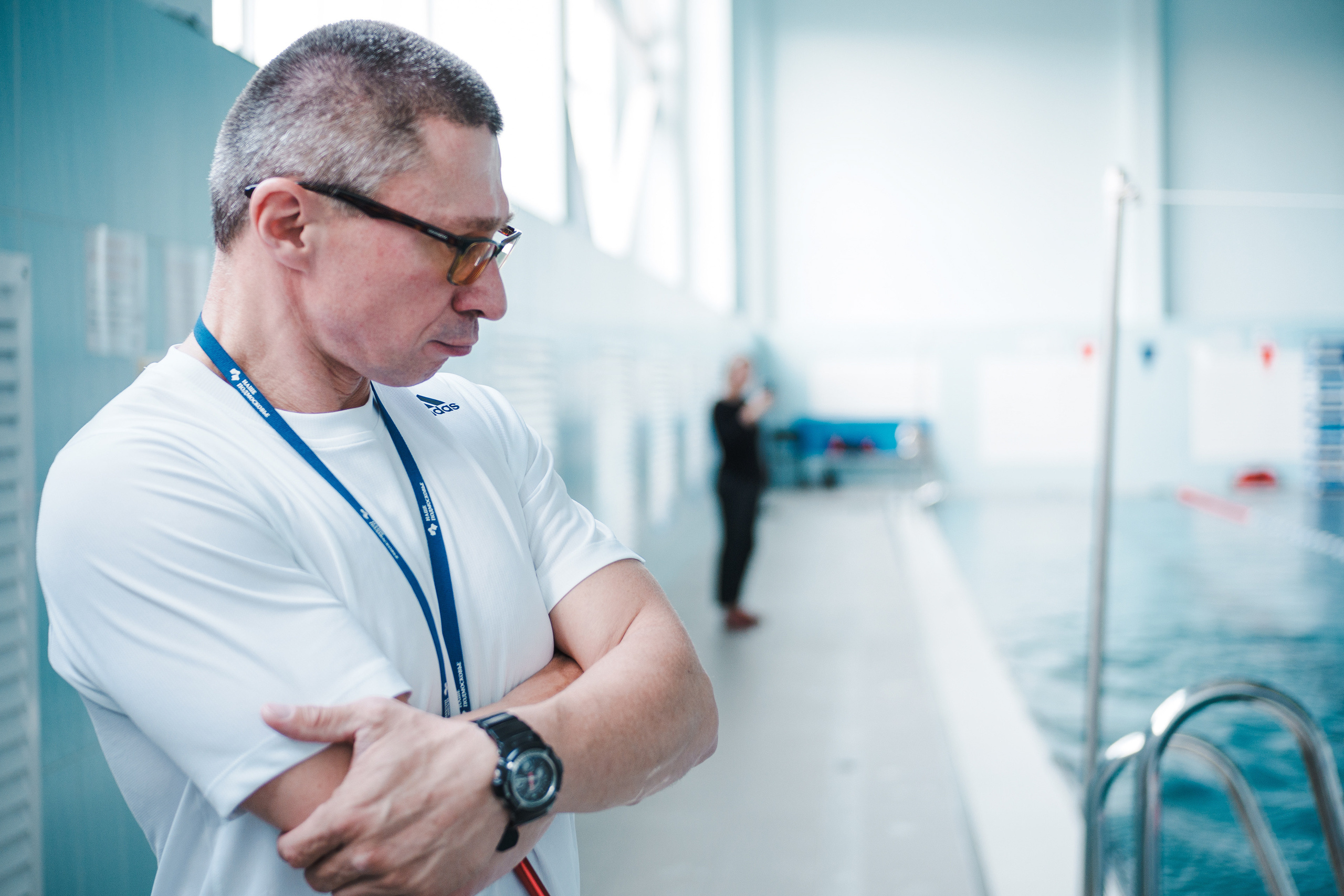 Яркий образ тренера по плаванию на фоне бассейна