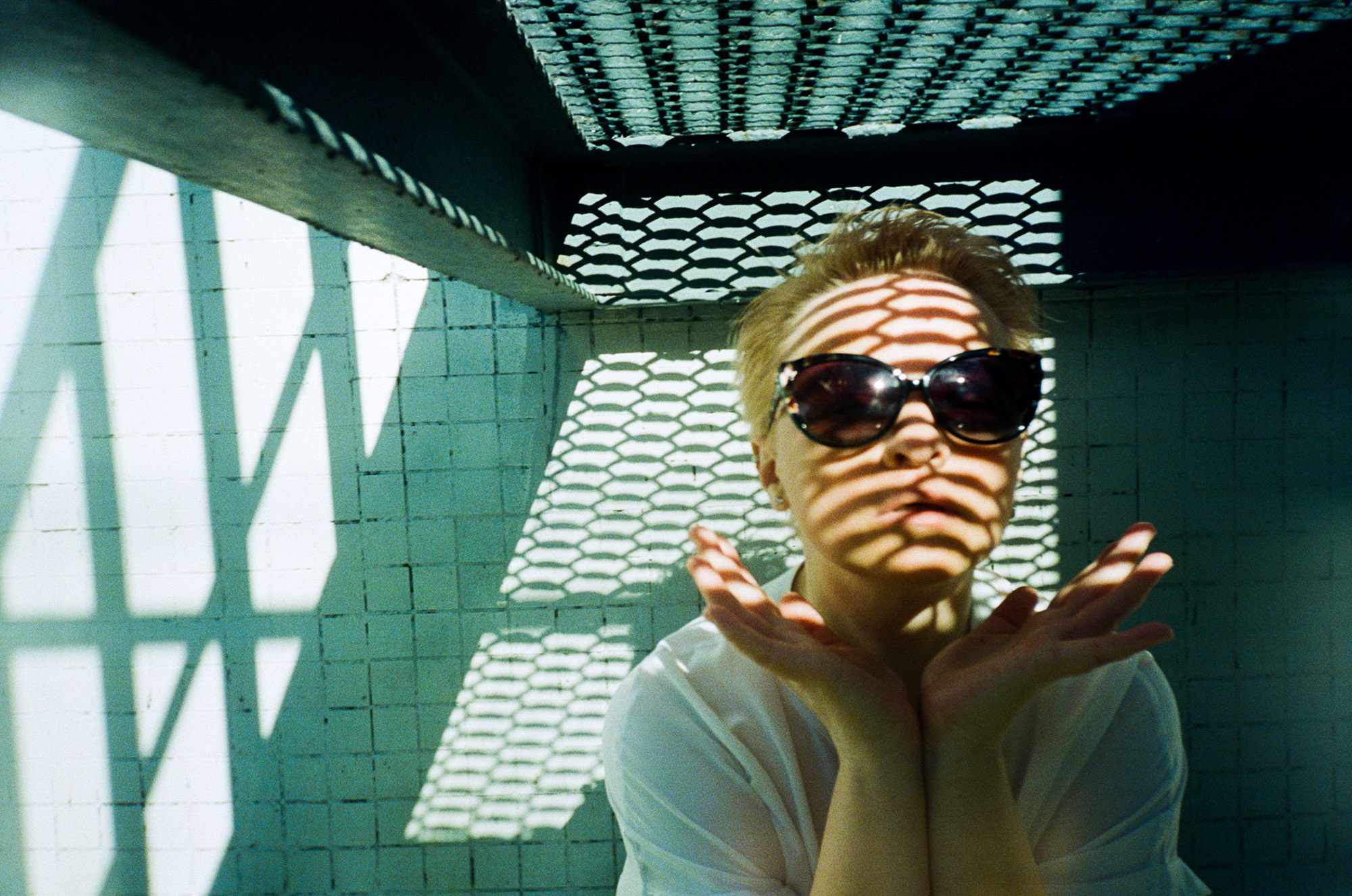 Фотосессия в уличном стиле, зеленые тона, теневая проекция, девушка в очках 