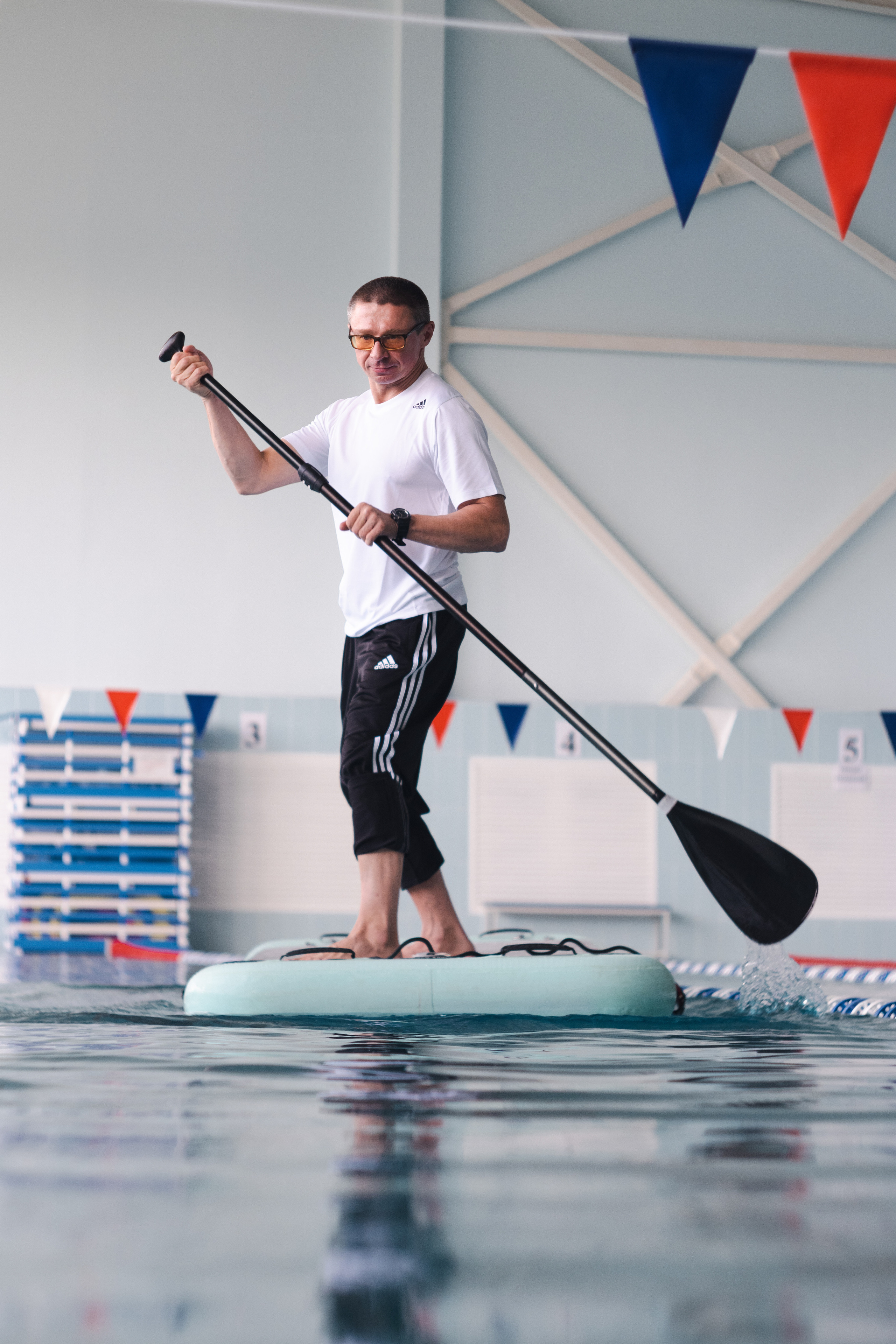 Тренер по плаванию в бассейне на сапборде