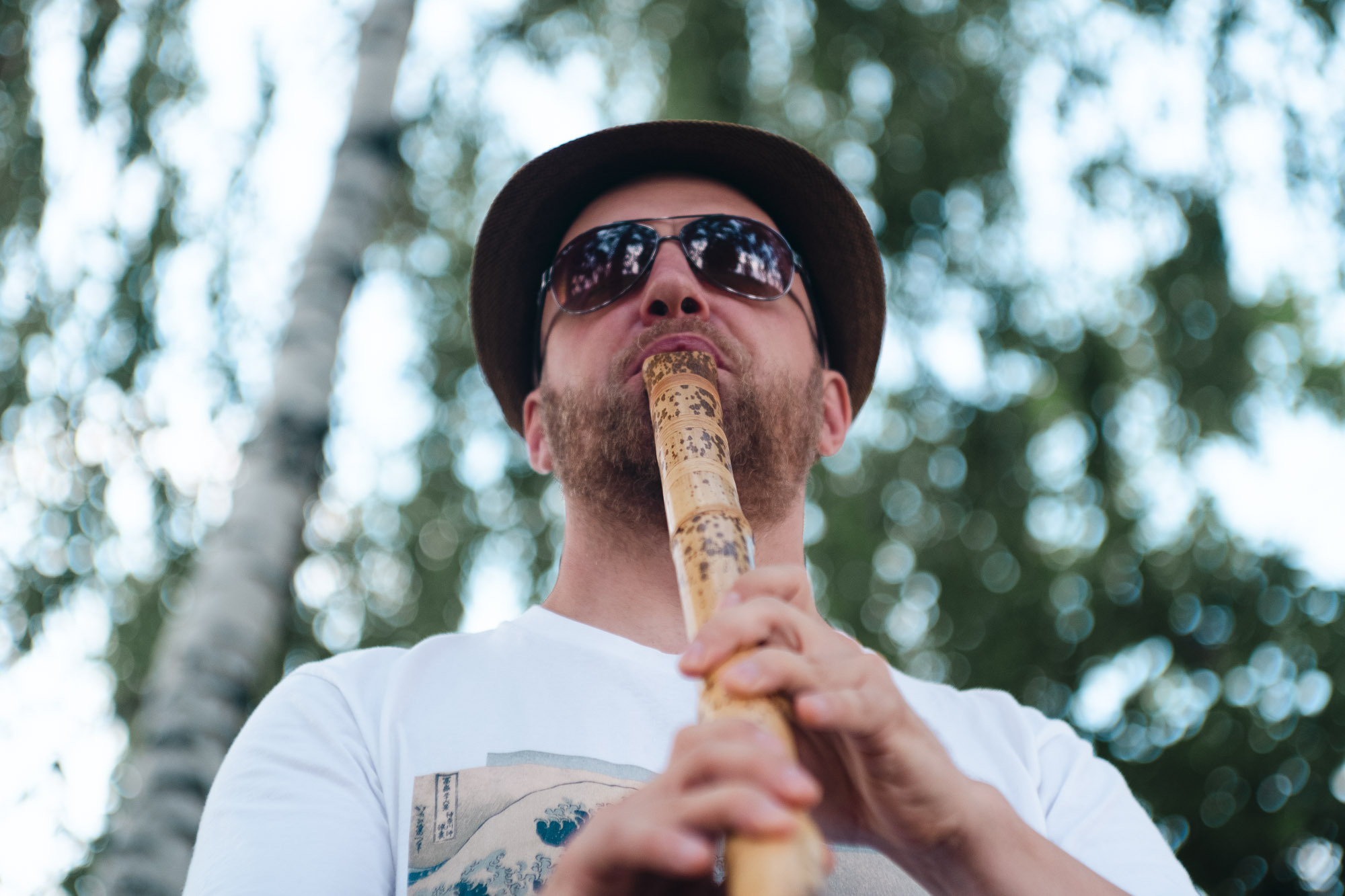 Портрет мужчины с бородой и флейтой летом в лесу в Москве