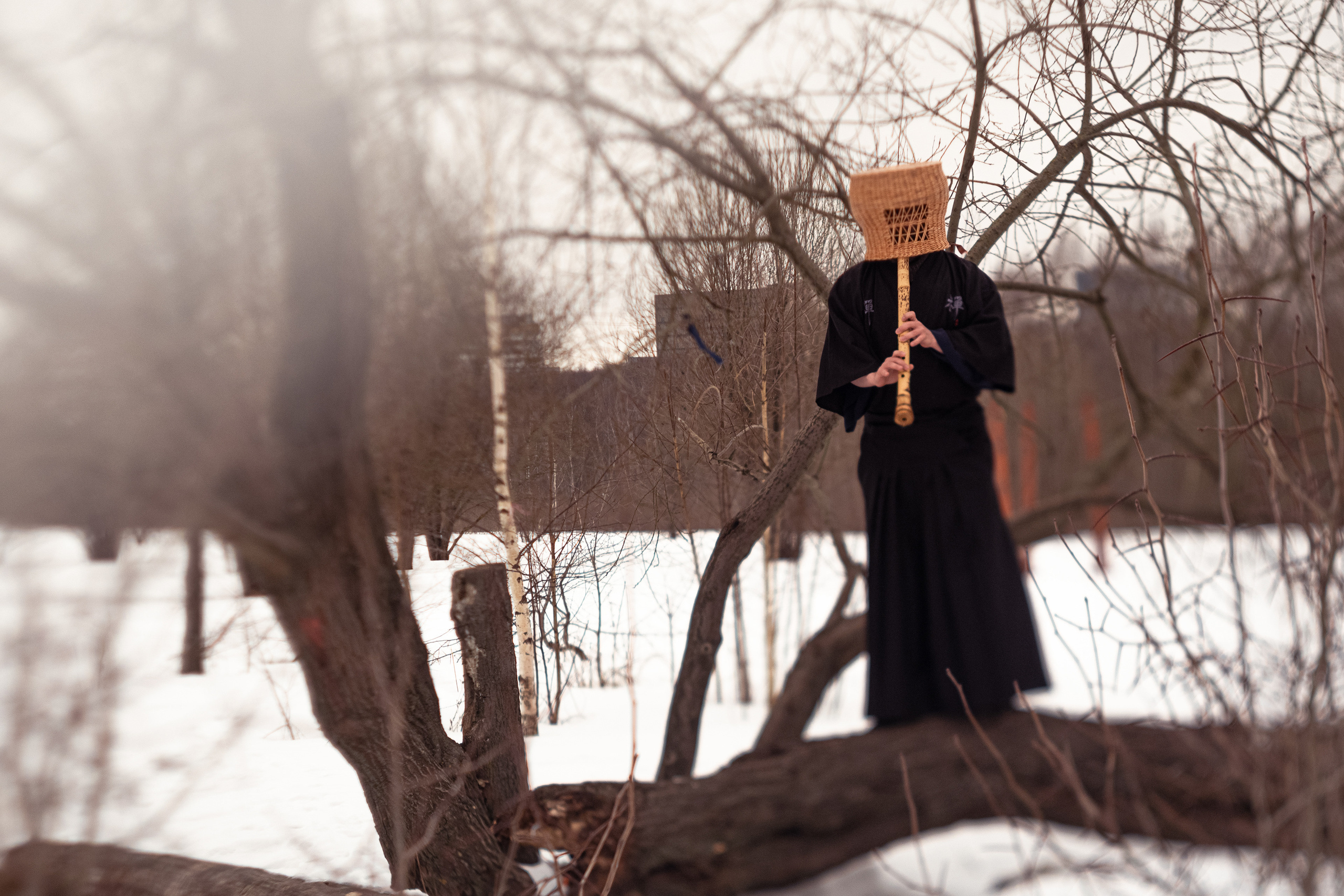 японский монах в шапке тенгай играет на сякухати в русском лесу зимой 