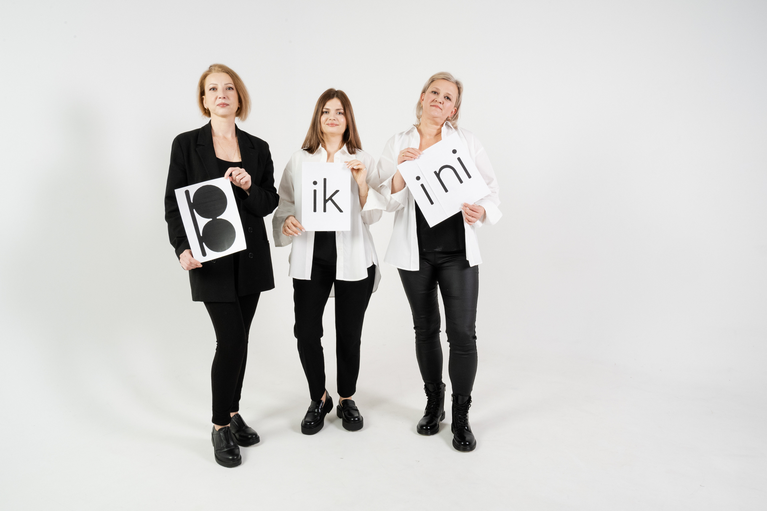 Корпоративная Фотосессия, три девушки держат листы бумаги с логотипом 