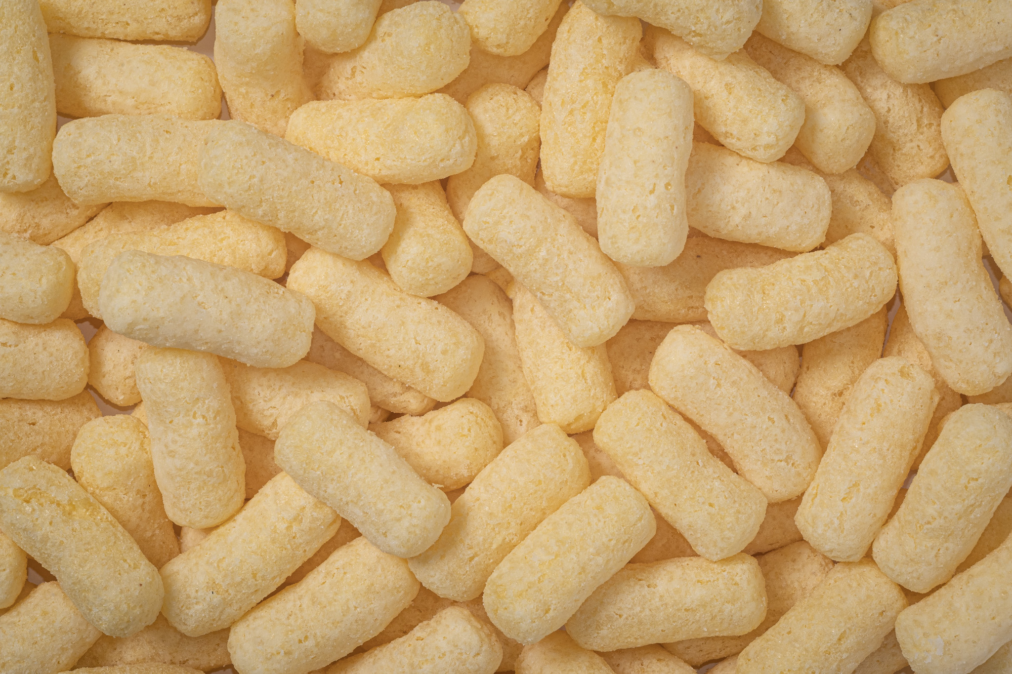 Вид сверху. Кукурузные хрустящие палочки словно полотно занимают весь кадр