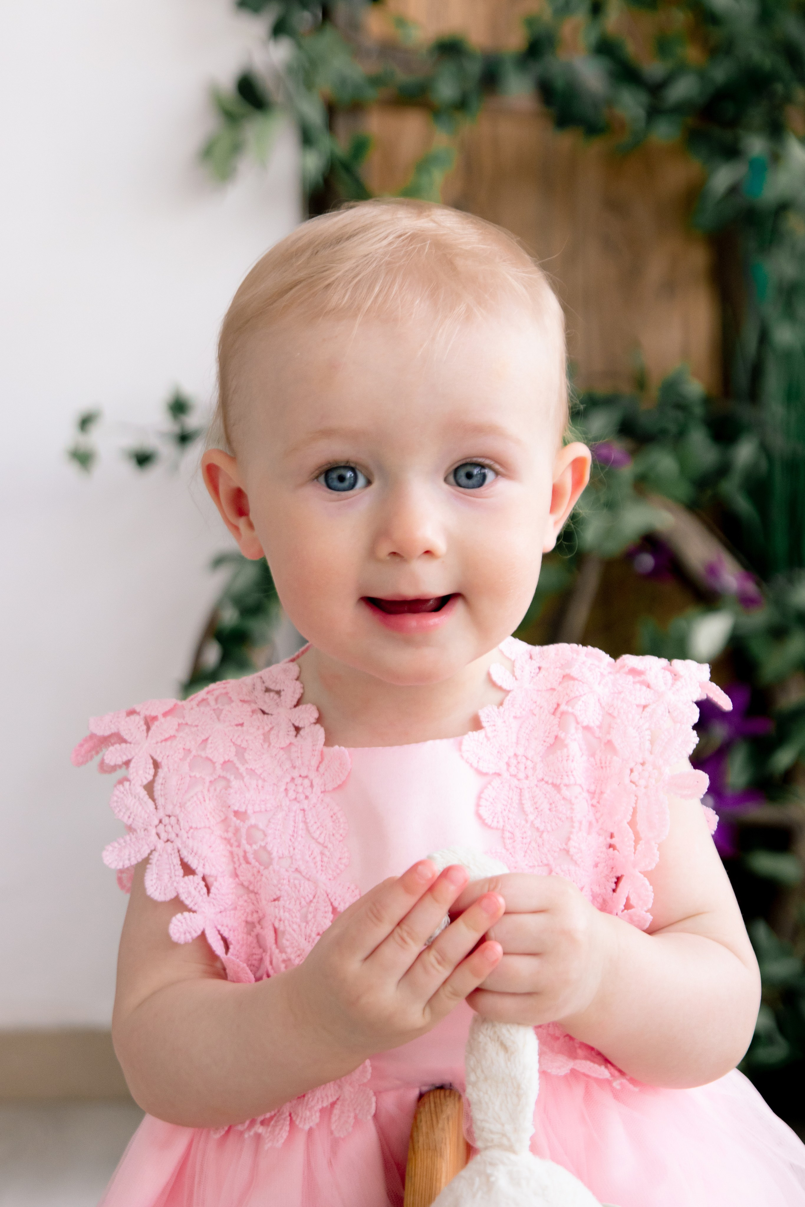 эмоциональная маленькая девочка в розовом платье с игрушкой в руках