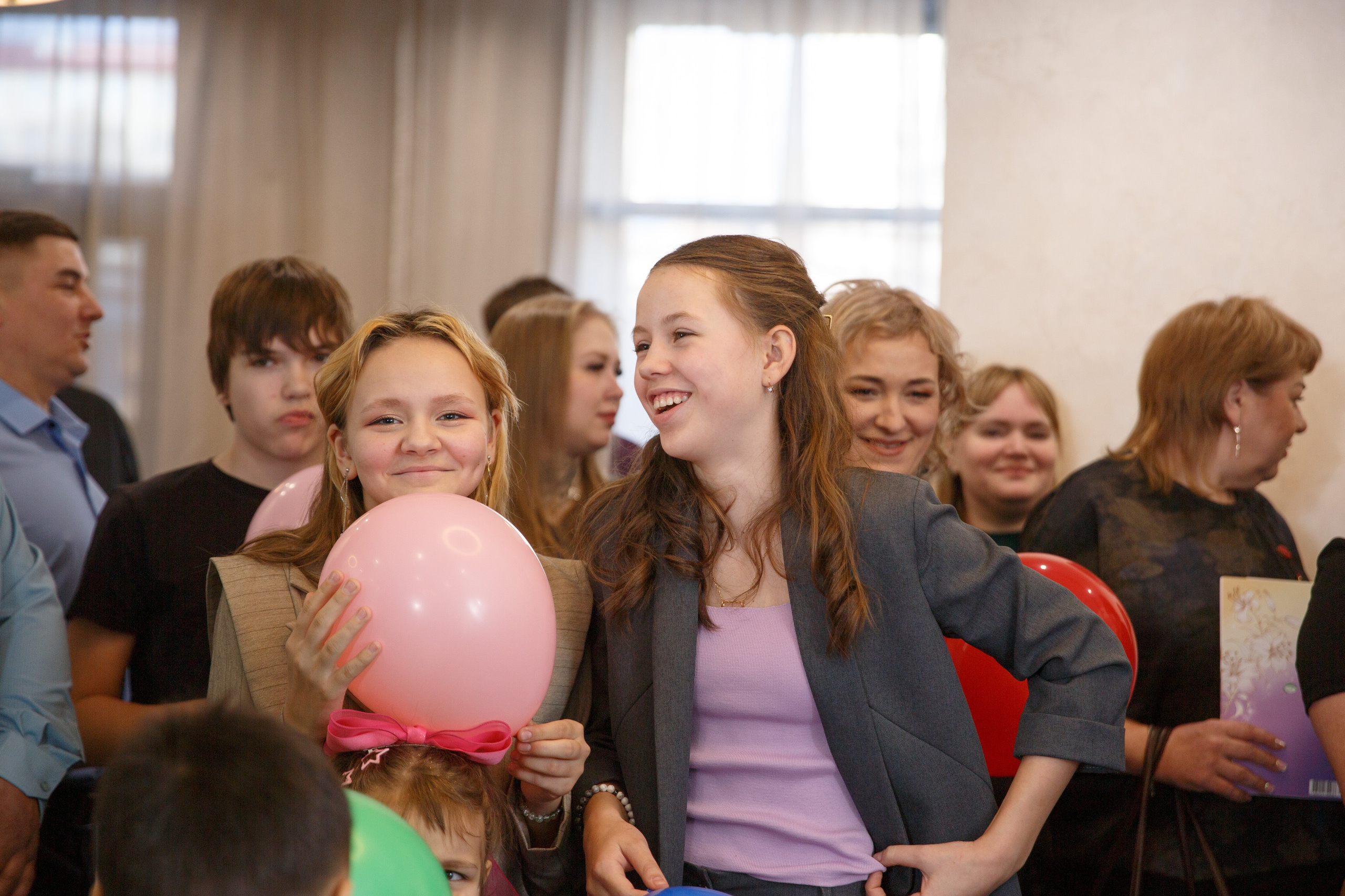 Гости поздравляют виновницу торжества, радостные лица и шары.