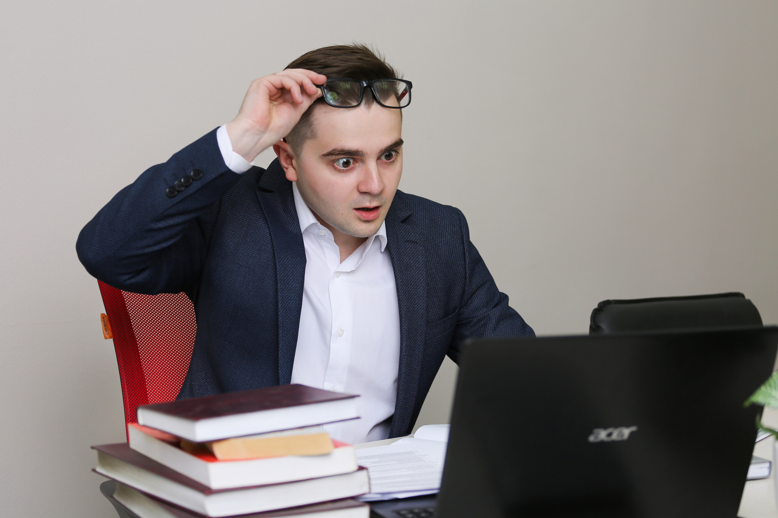 Парень удивился он сидит в окружении книг и журналов