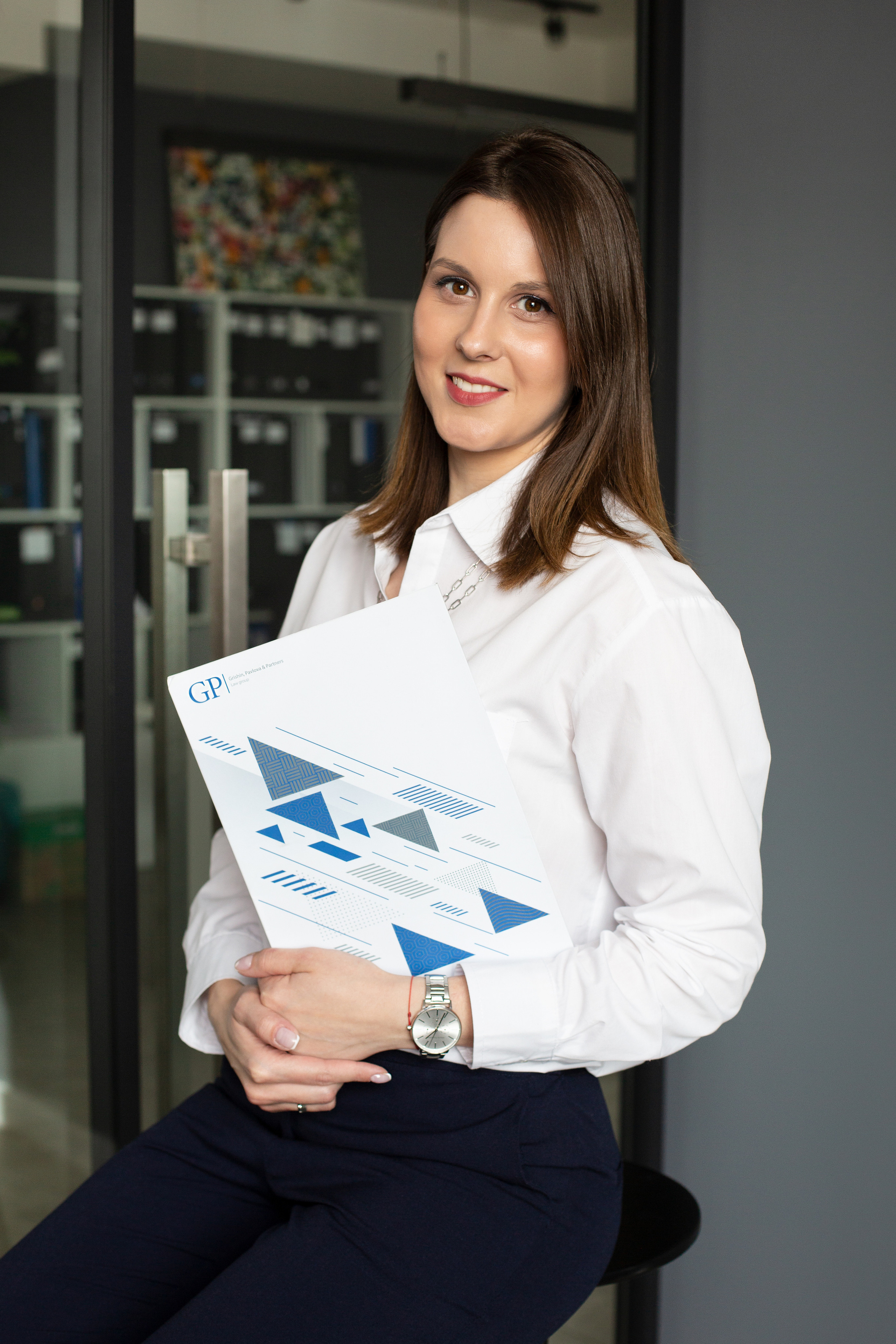 Девушка улыбается фотографу в офисе