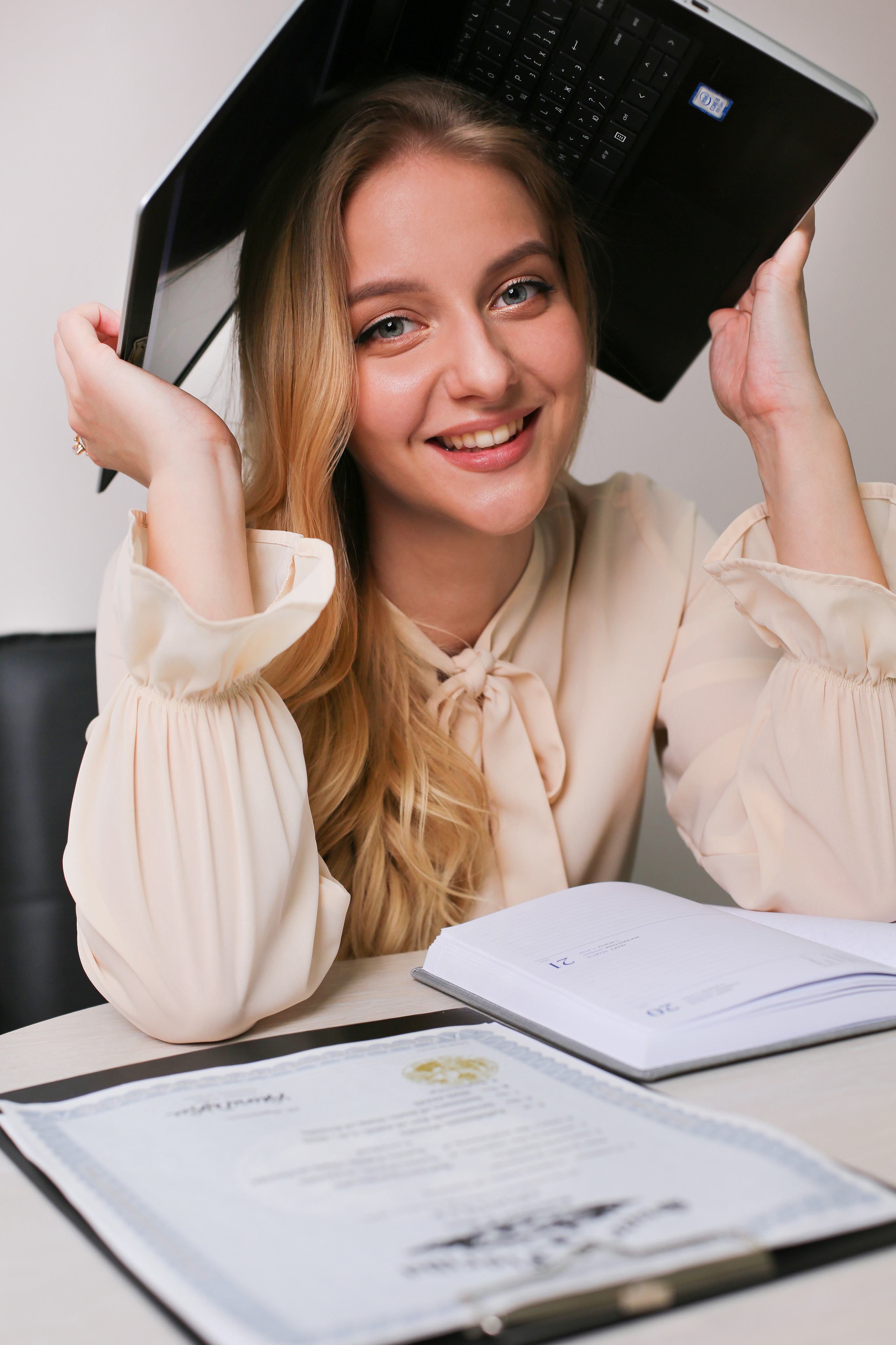 Девушка спрятала свою голову под рабочей папкой 