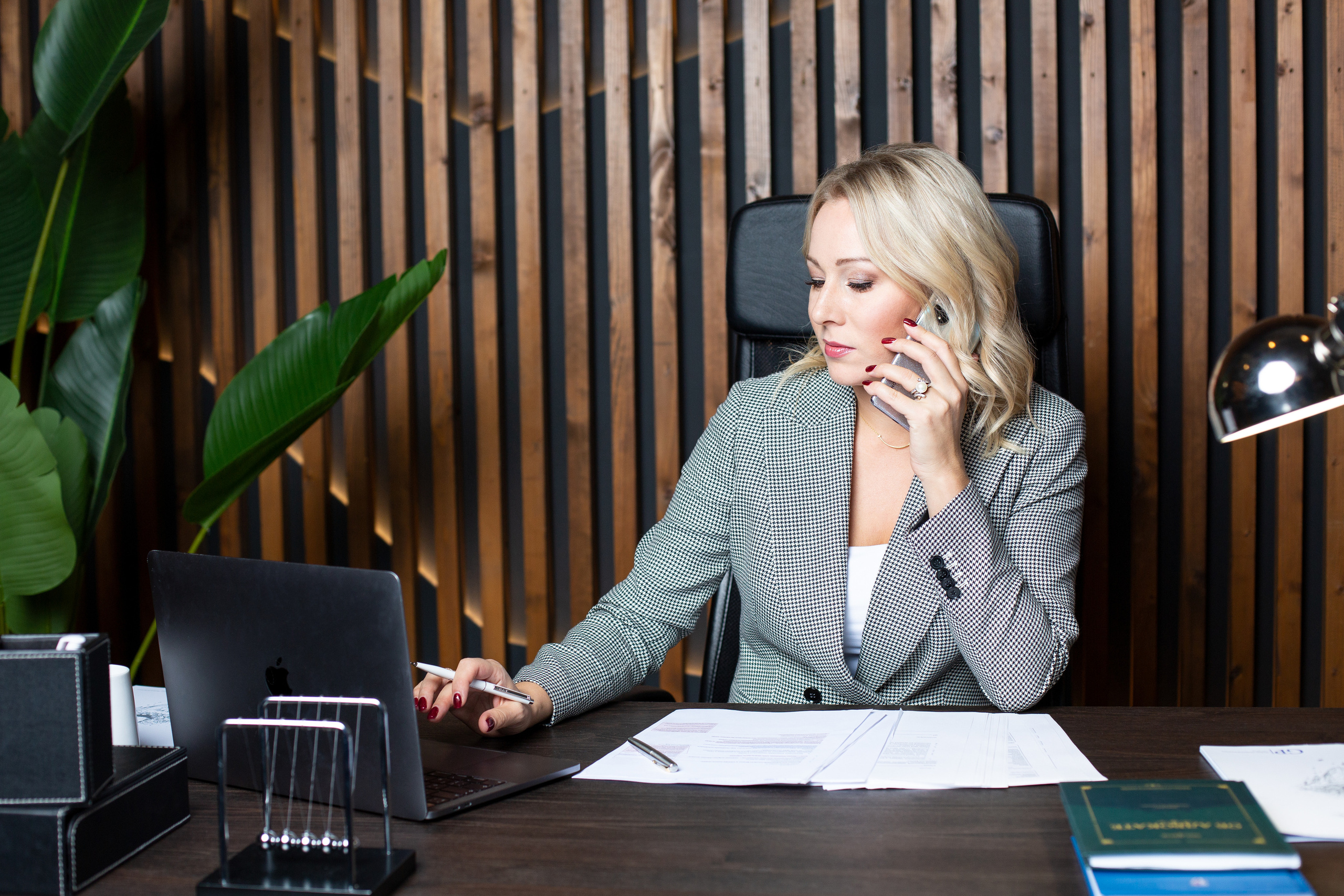 Красивая бизнес леди сидит в кабинете за рабочим столом