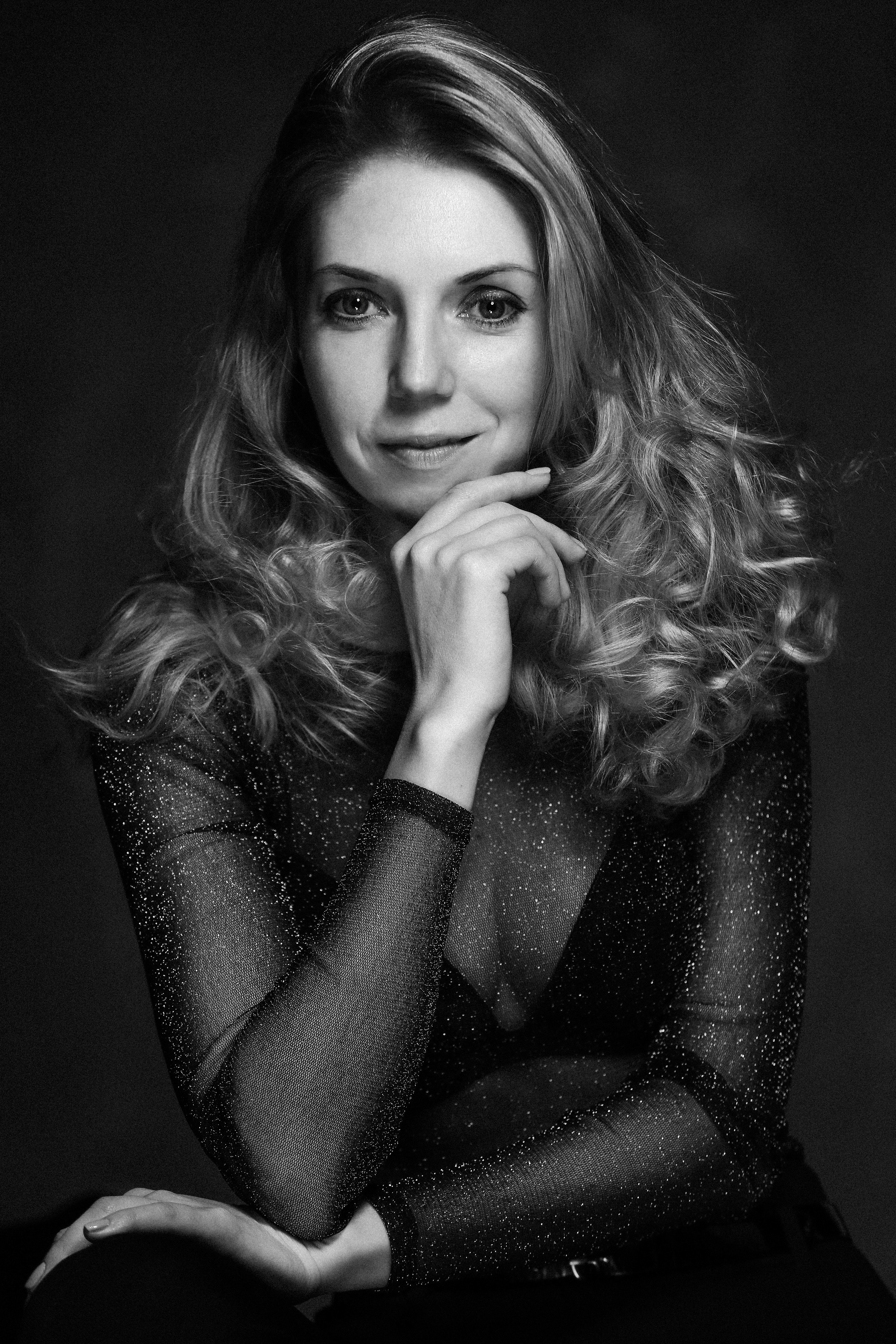 Улыбающаяся женщина с красивыми волнистыми волосами фотографируется