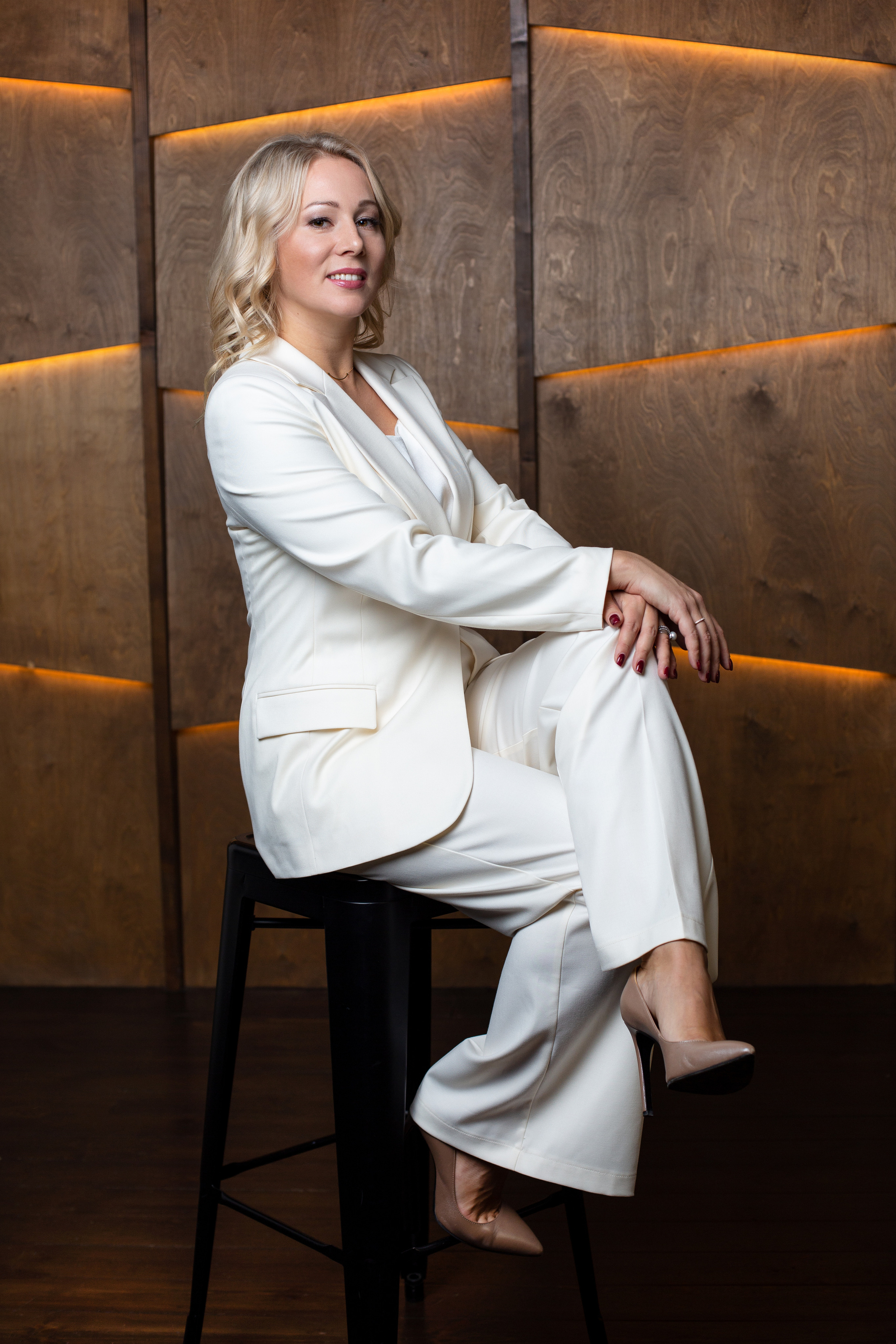 Девушка сидит на высоком стуле в фотостудии