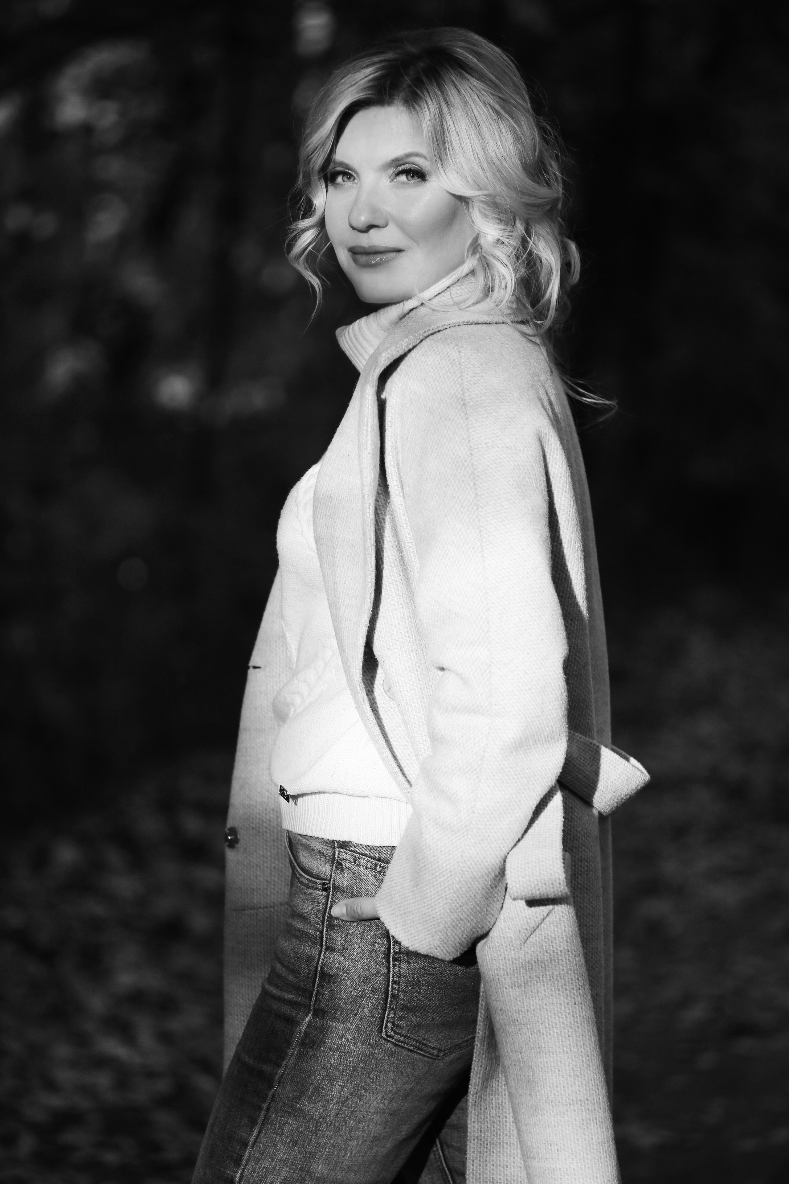 Девушка в белом пальто улыбается мен