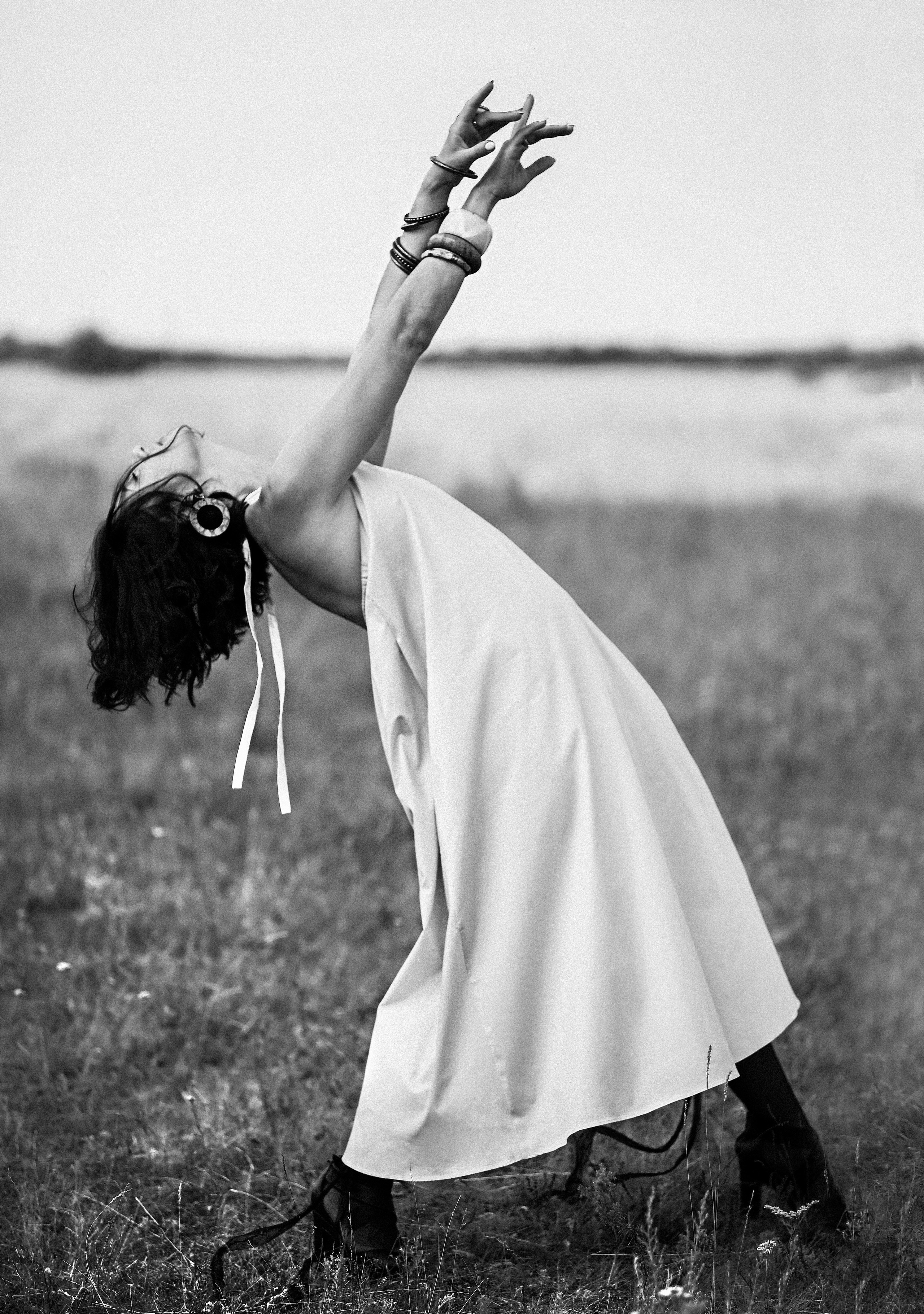 Девушка танцует в поле браслеты на руках