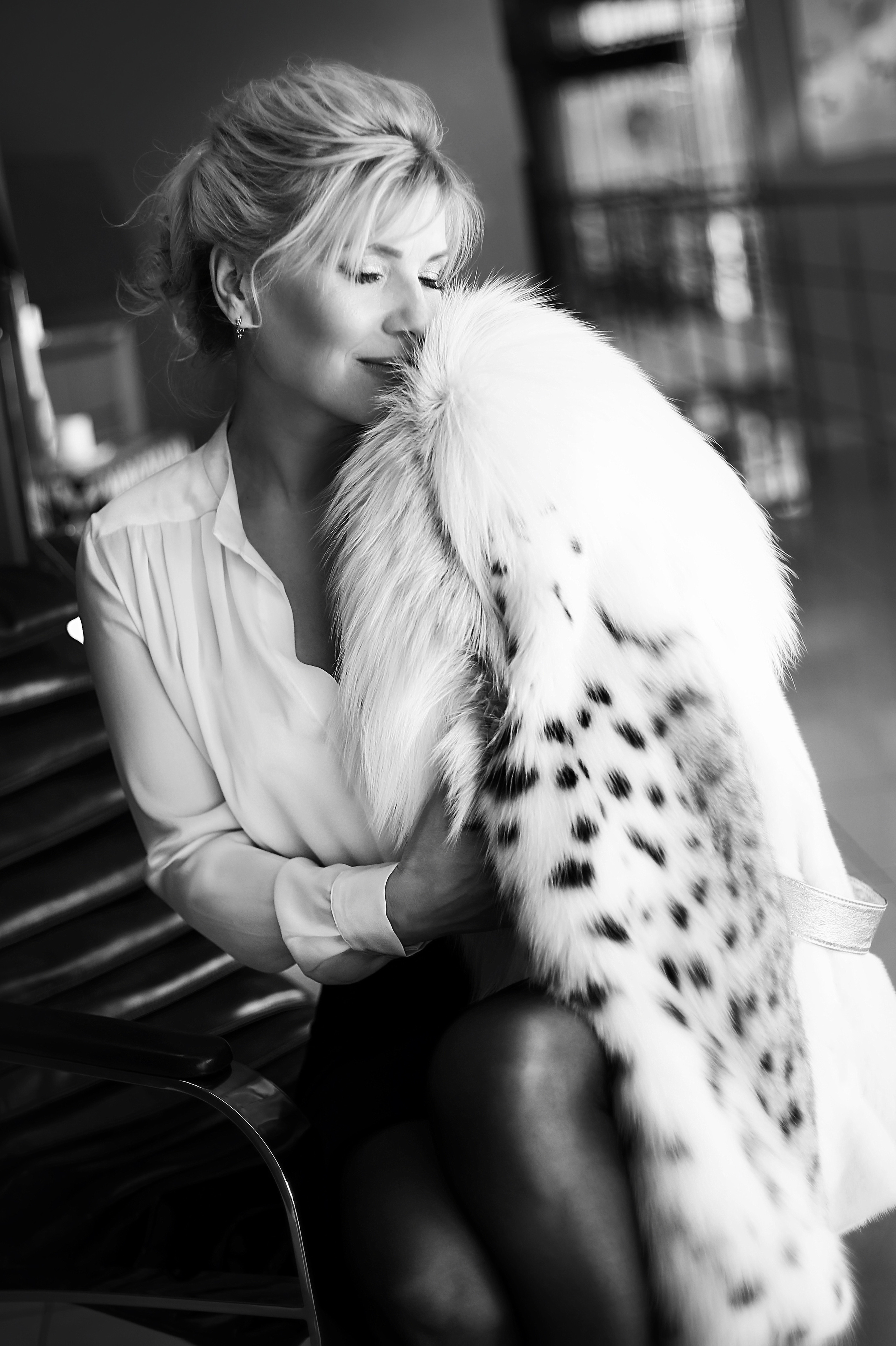 Блондинка в меховой шубке улыбается