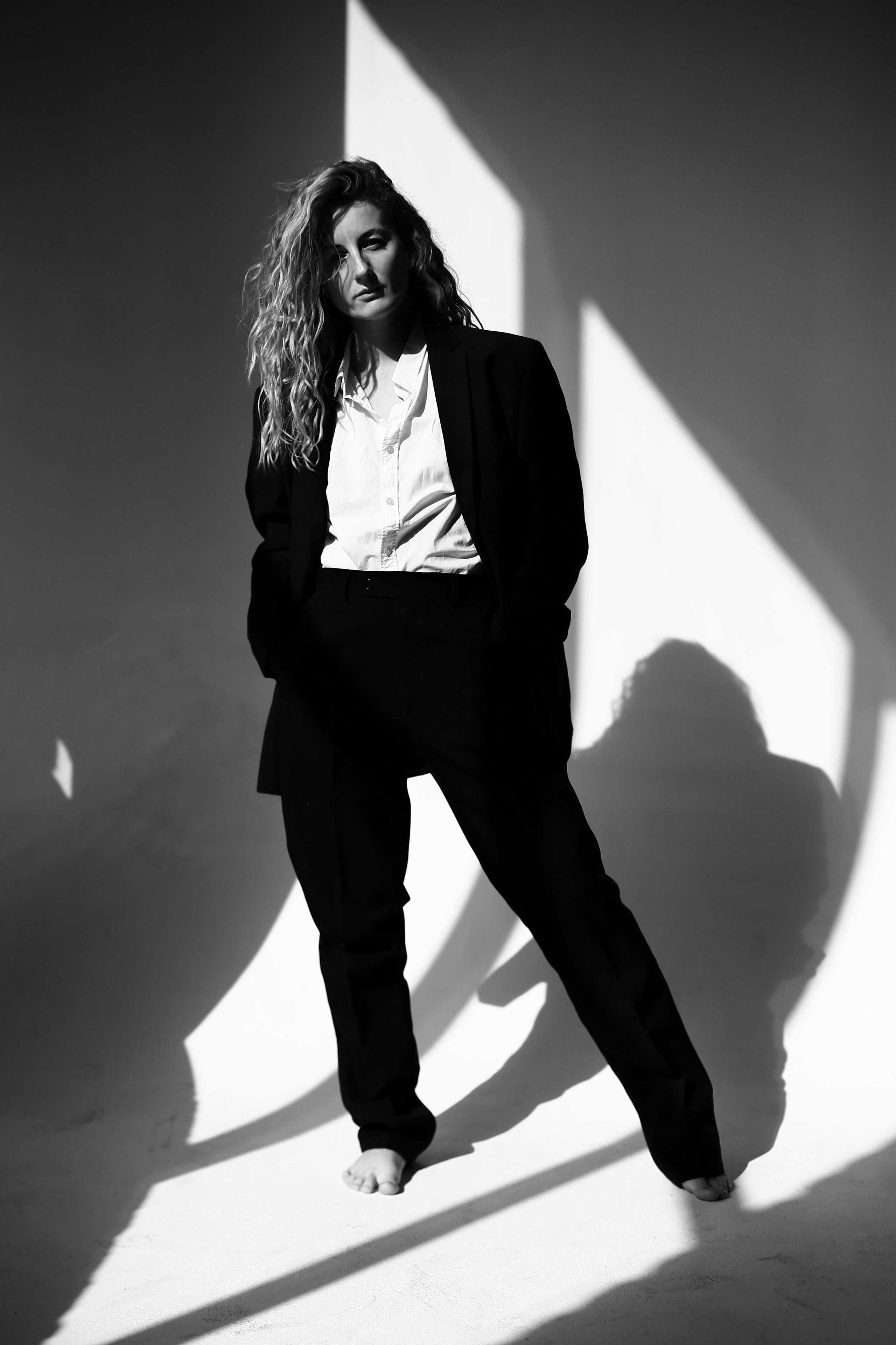 Девушка в мужском костюме ч волнистыми волосами