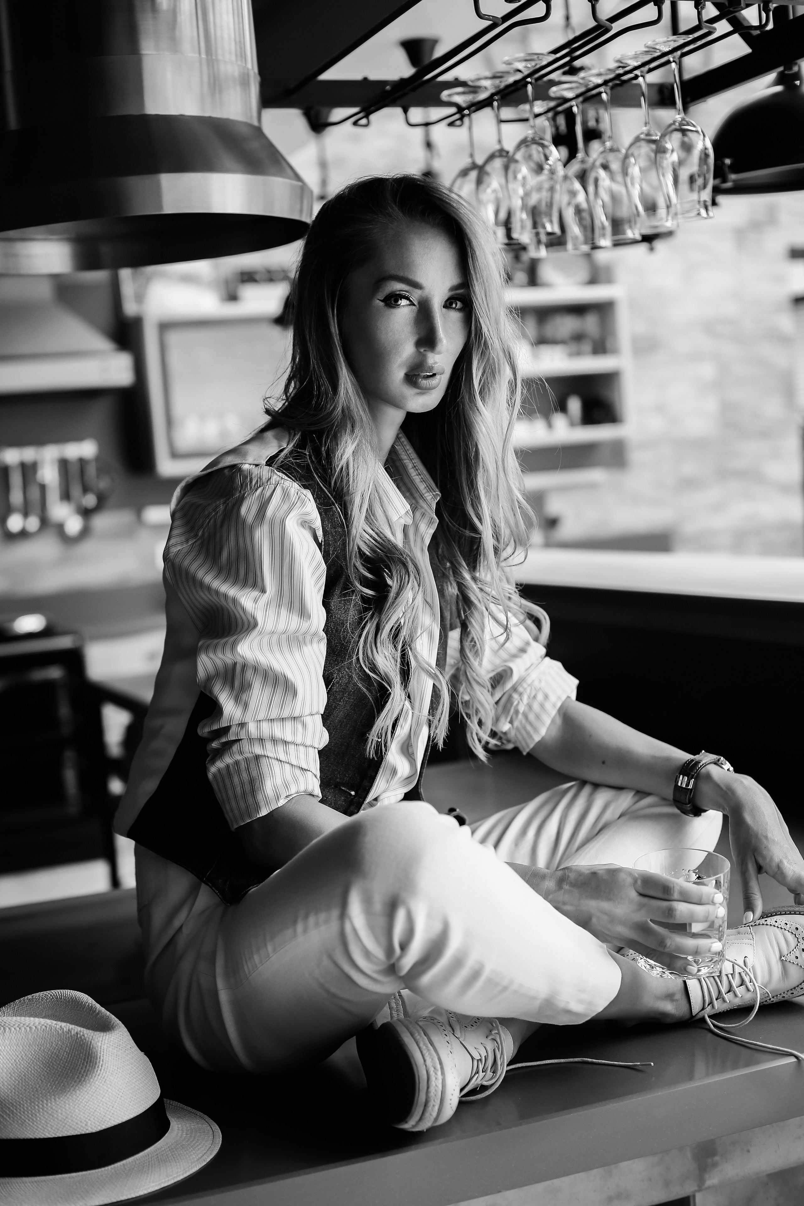 Красивая женщина сидит на столе в кухне 