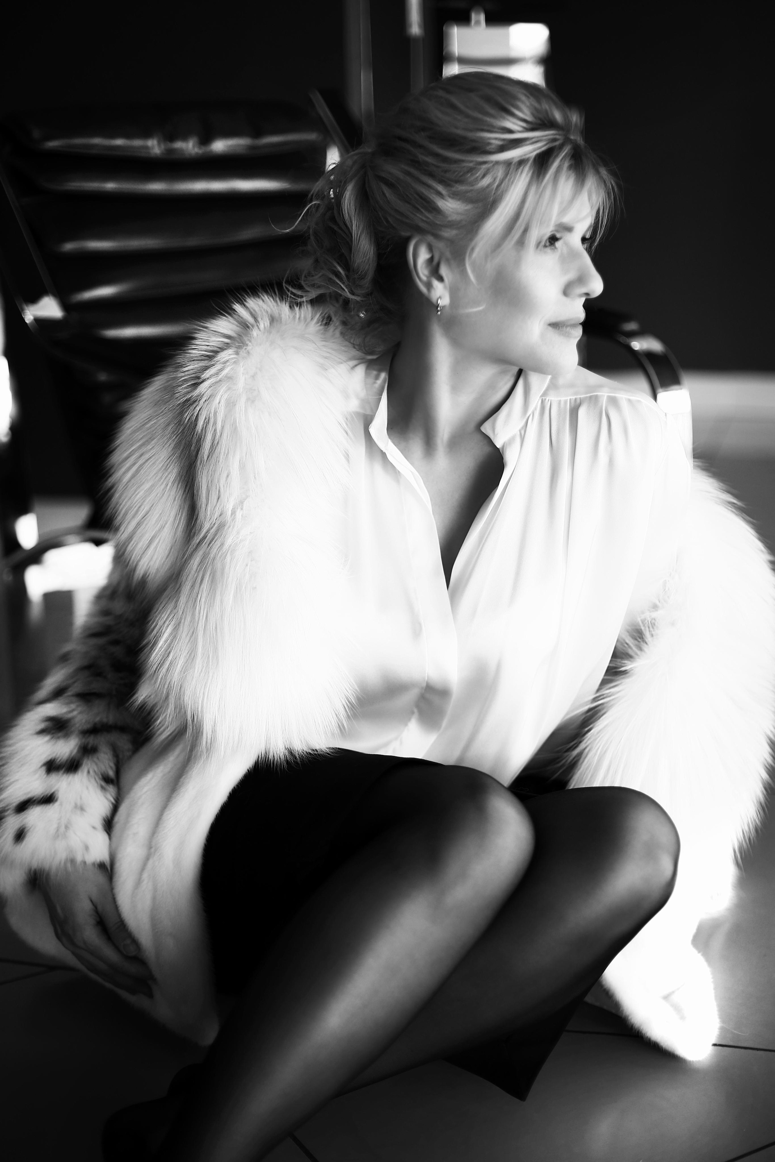 Женщина зрелого возраста в меховом манто смотрит в даль