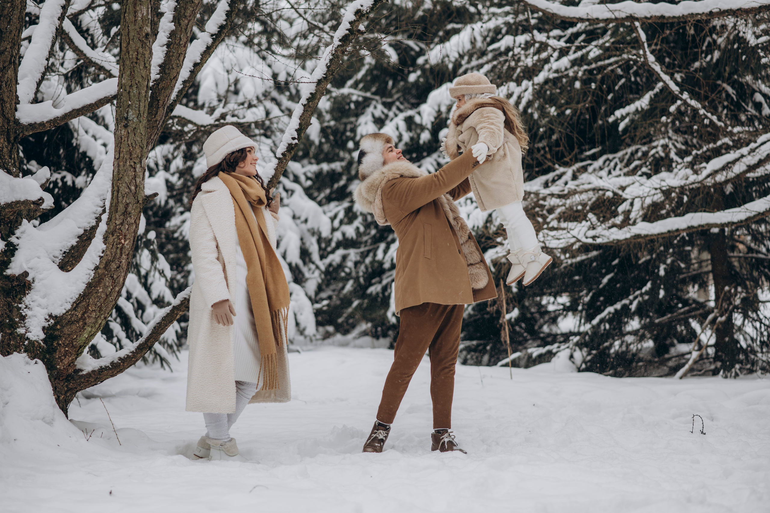 Семейная фотосессия зимой, папа поднимает ребенка на руки