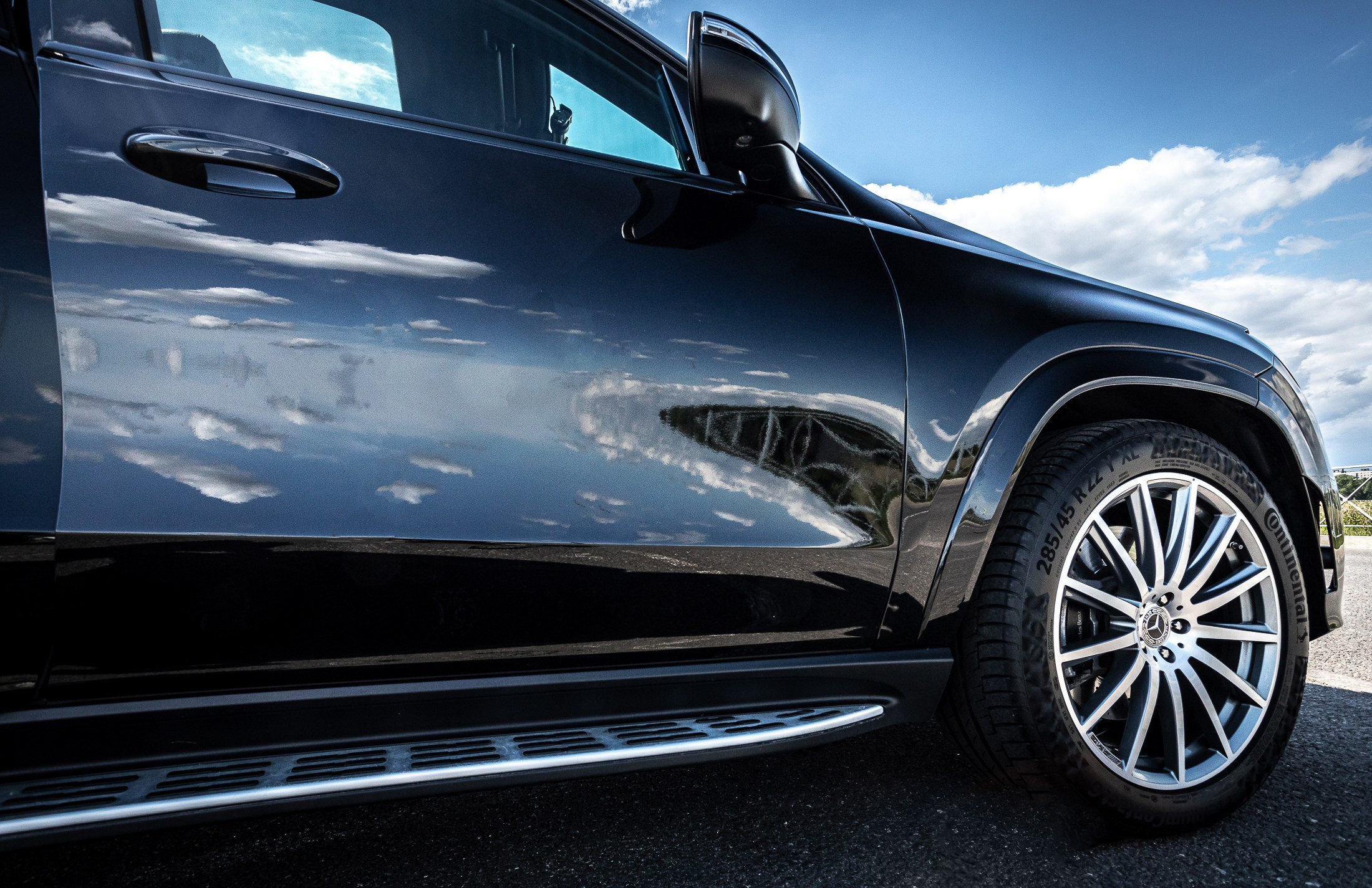 Отражение улицы в боковой двери автомобиля.