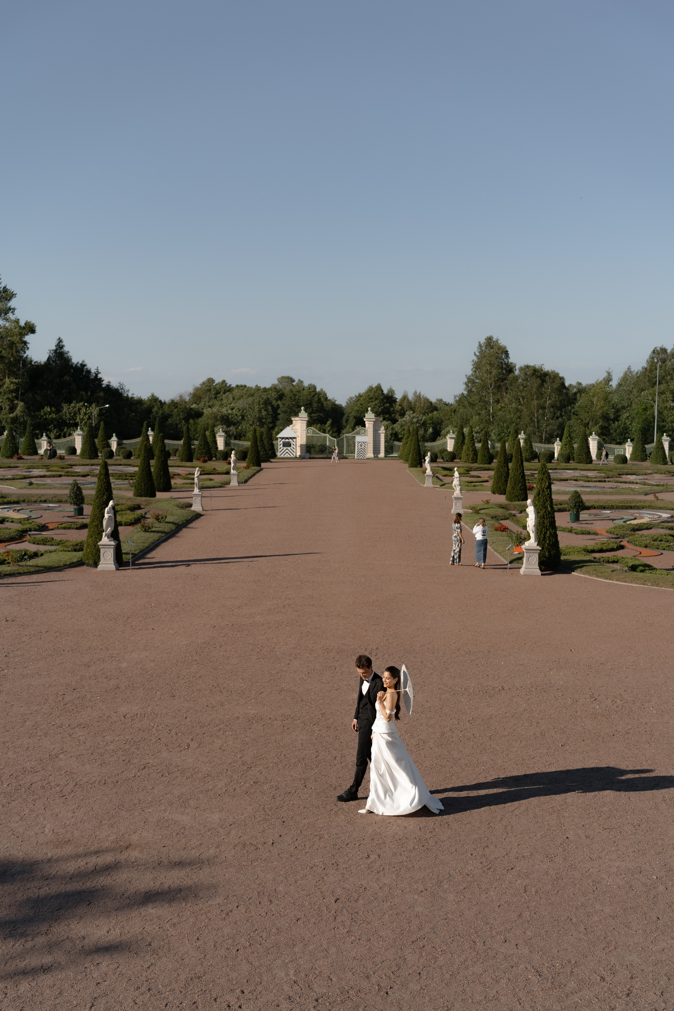 Невеста с зонтом на широкой аллее парка Ораниенбаум