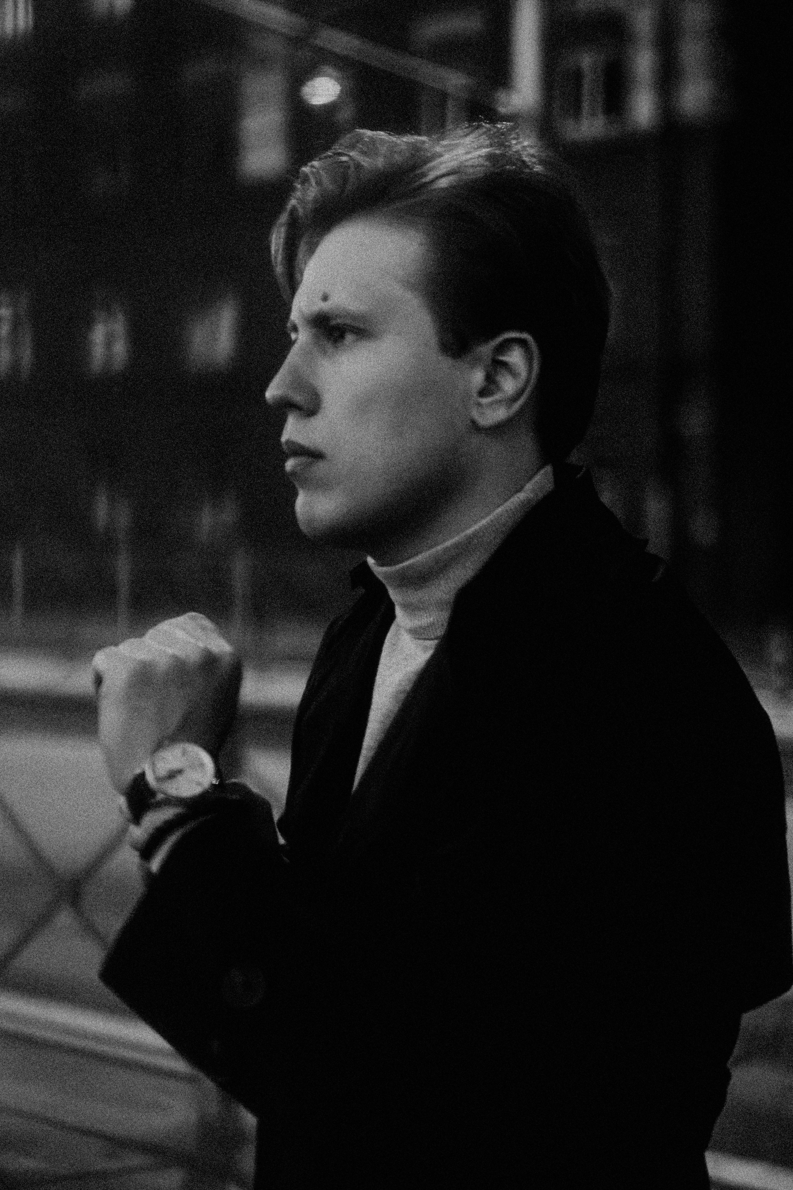 Мужчина в профиль надевает часы в ч/б