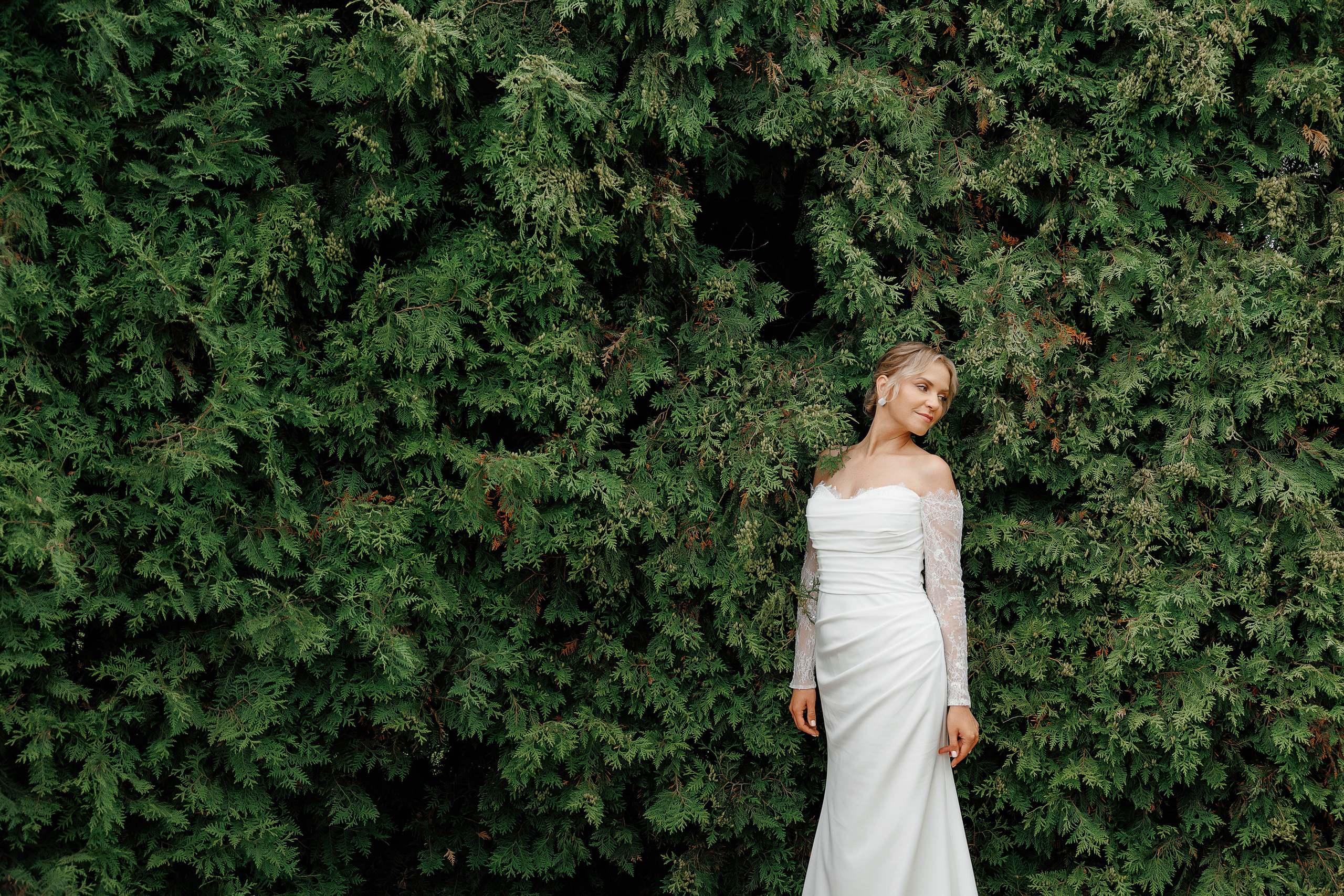 Свадебная фотосессия в Музее Веневитинова Невеста стоит у стены туй