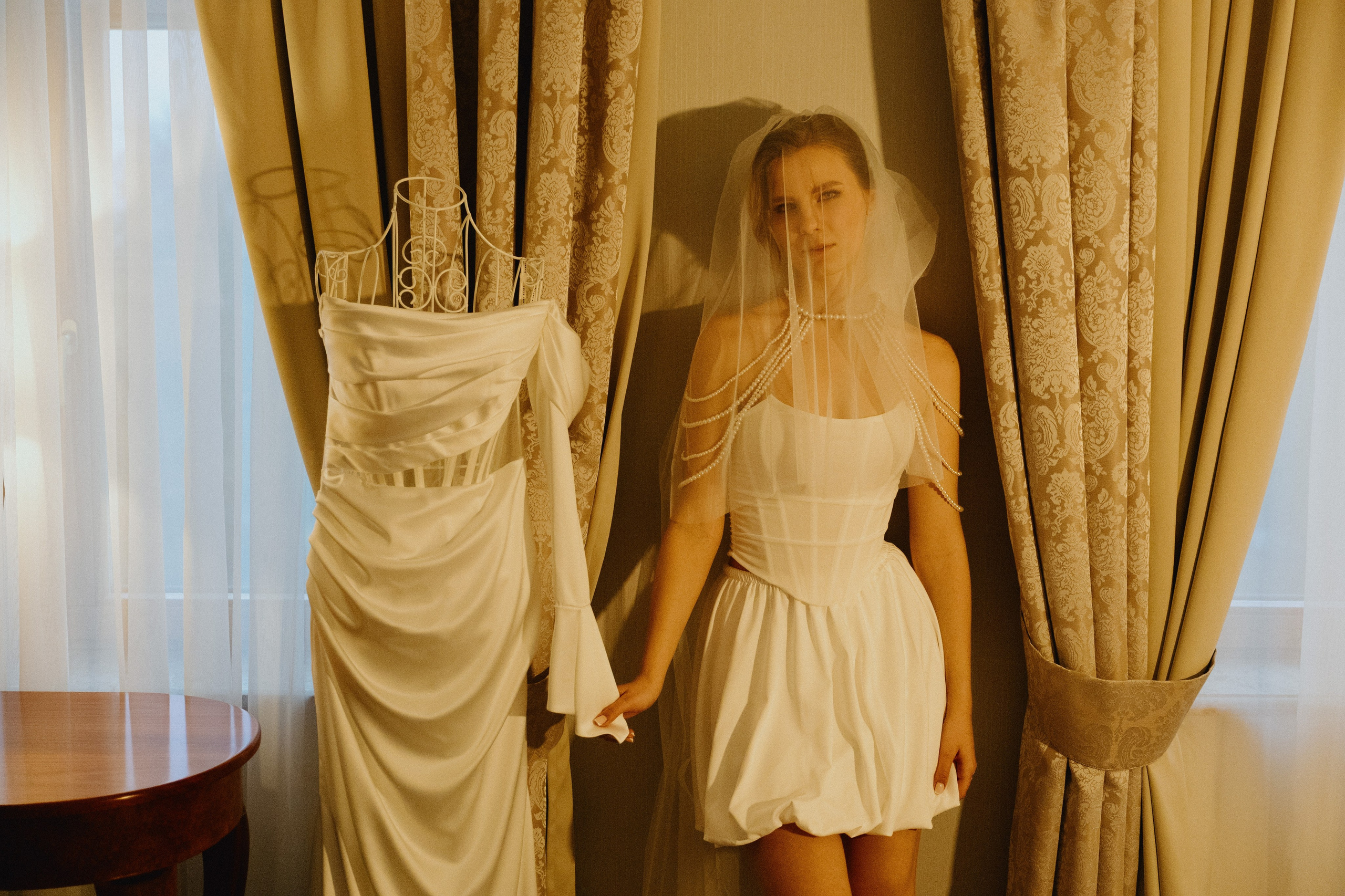 Невеста в жемчугах: Невеста держит свадебное платье с жемчужным ожерельем.