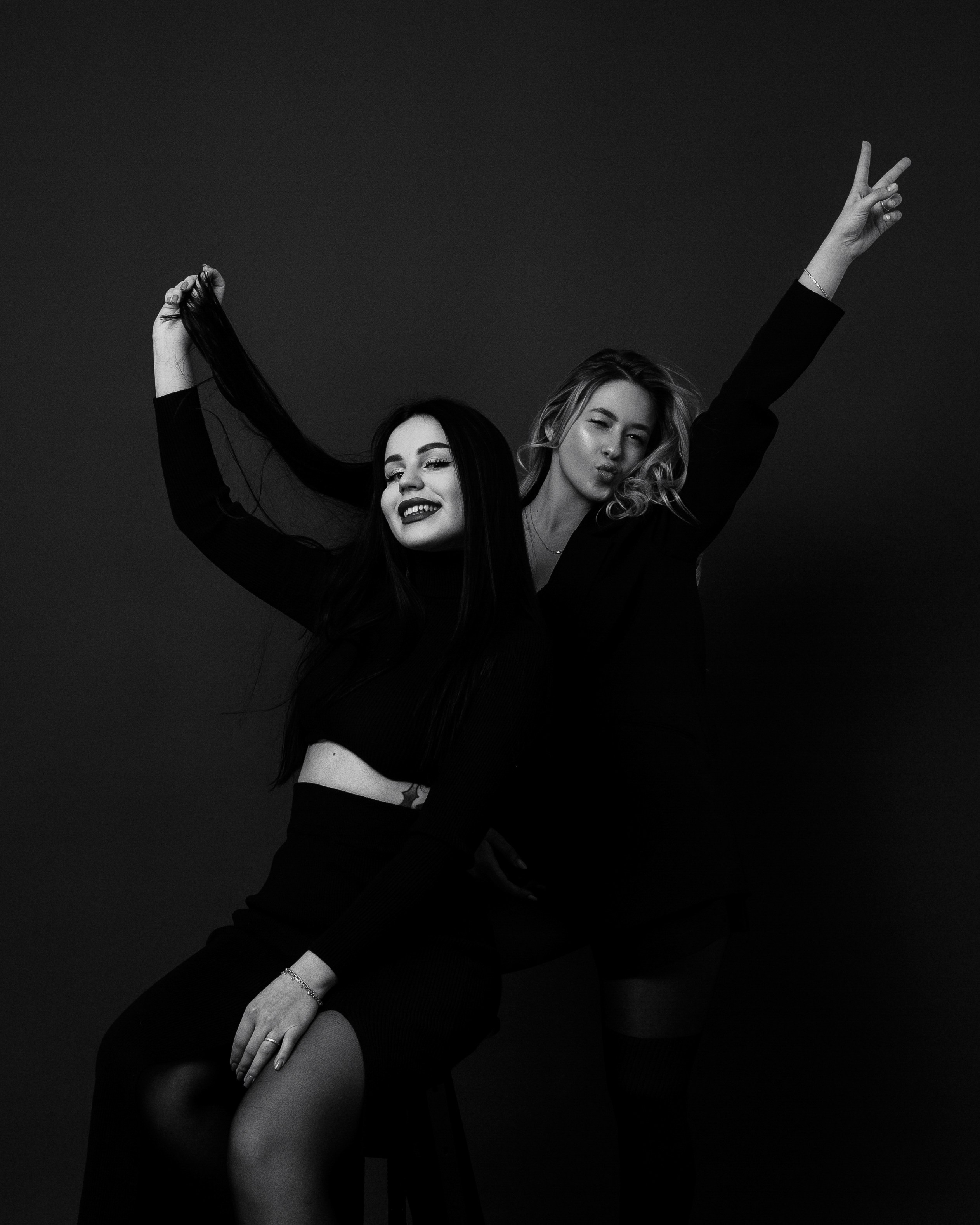 Две девушки в черно одежде позируют для фотографии