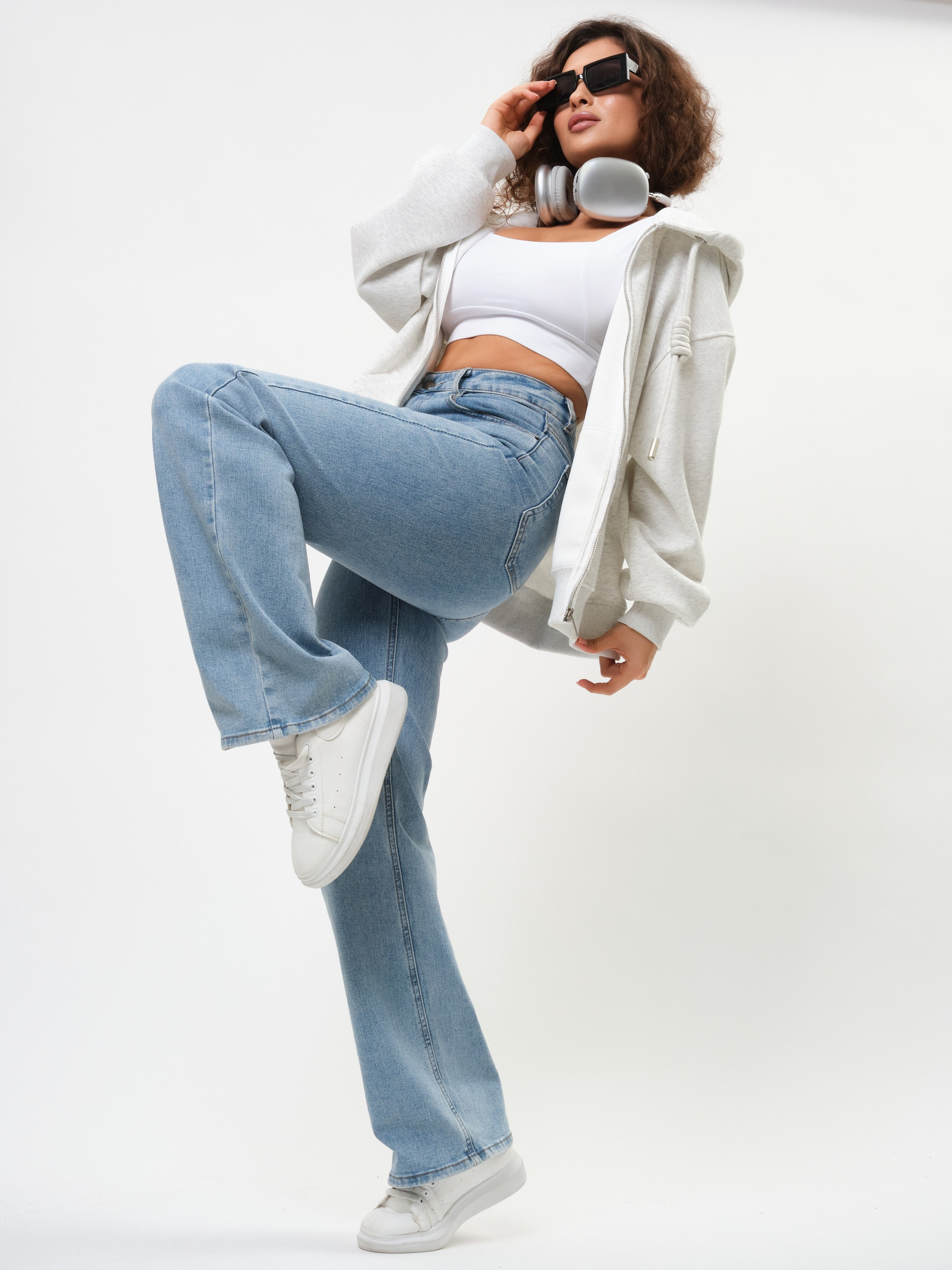 Девушка в синих джинсах и светлой толстовке