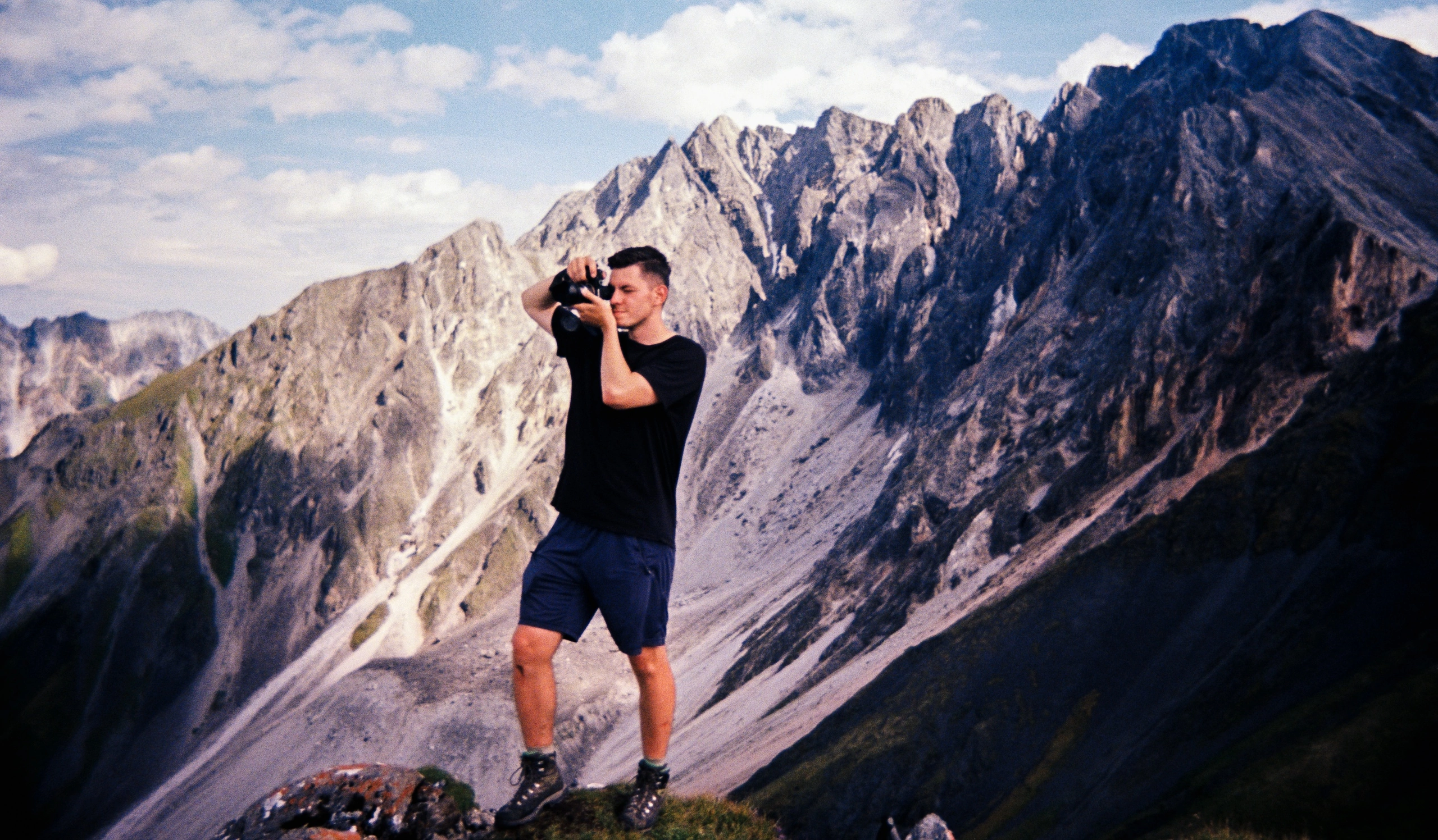 Мужчина, спортивный фотограф, снимает горы на открытом воздухе