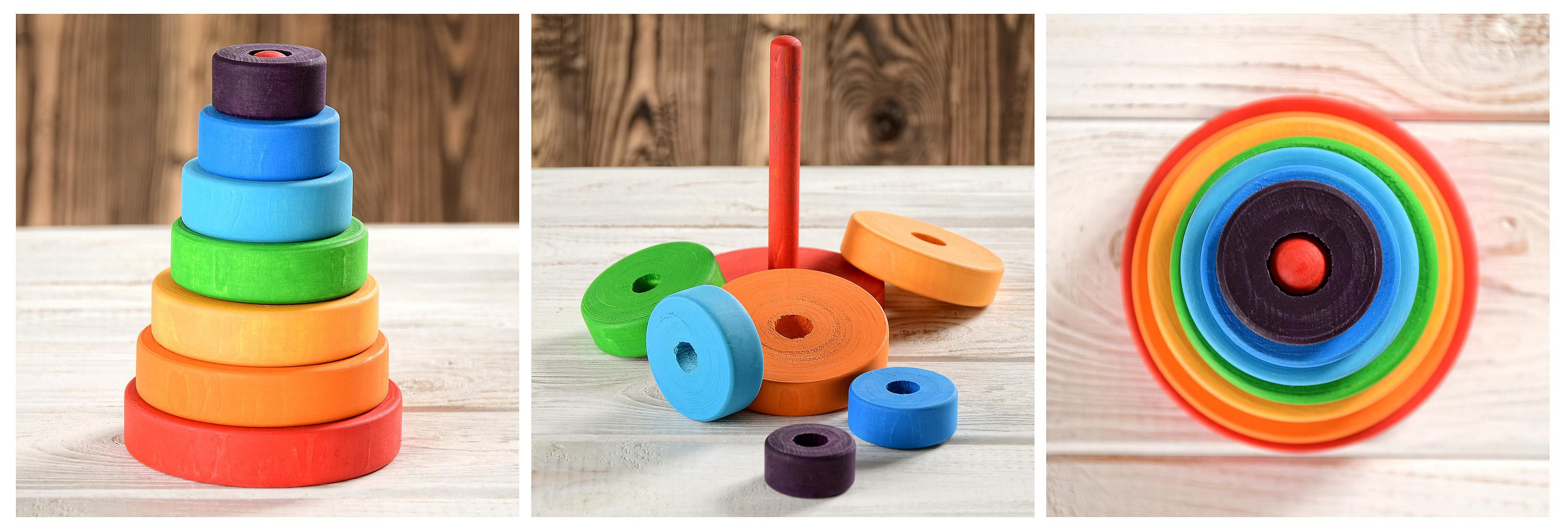 Деревянная радужная разноцветная яркая пирамидка на дощатом фоне.