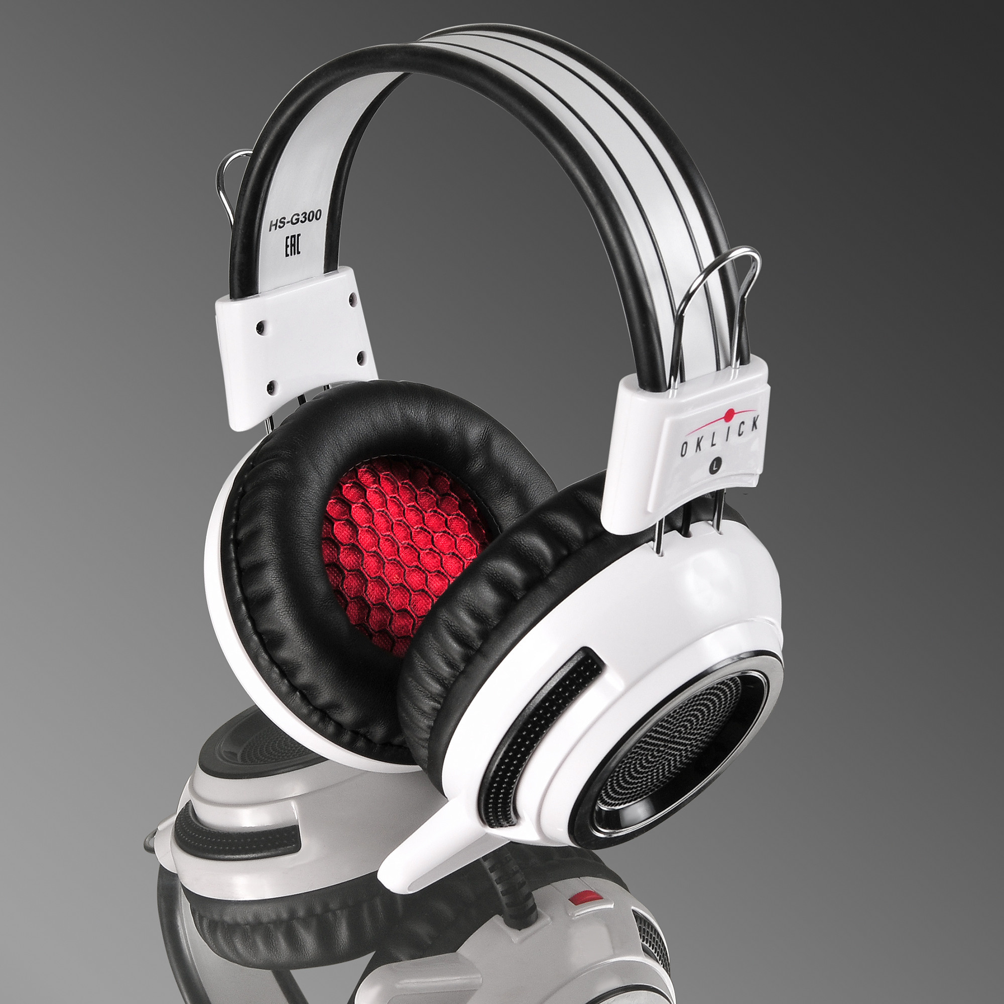 Белые с серым большие наушники на зеркале.