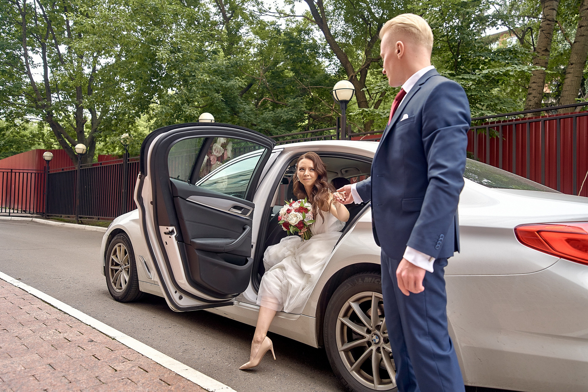 жених помогает невесты выйти из свадебного автомобиля.  - Отель Интурист Коломенское Фотограф на свадьбу в Москве Сергей Гаварос. gavaros.ru