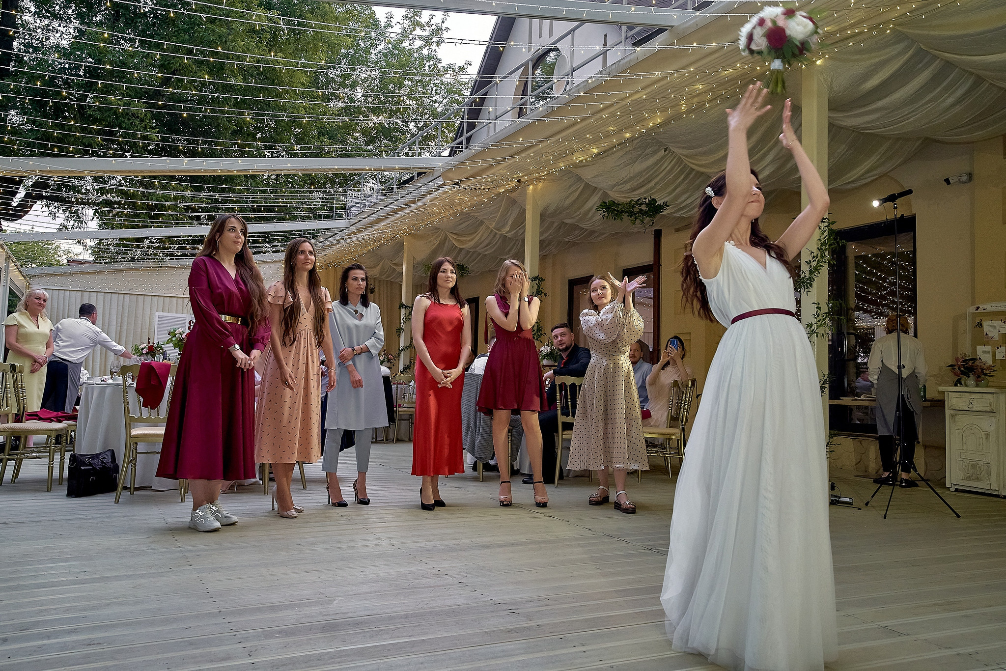 Невеста бросает букет подругам на свадебном банкете.  Свадебный фотограф на свадьбу в Москве Сергей Гаварос. gavaros.ru