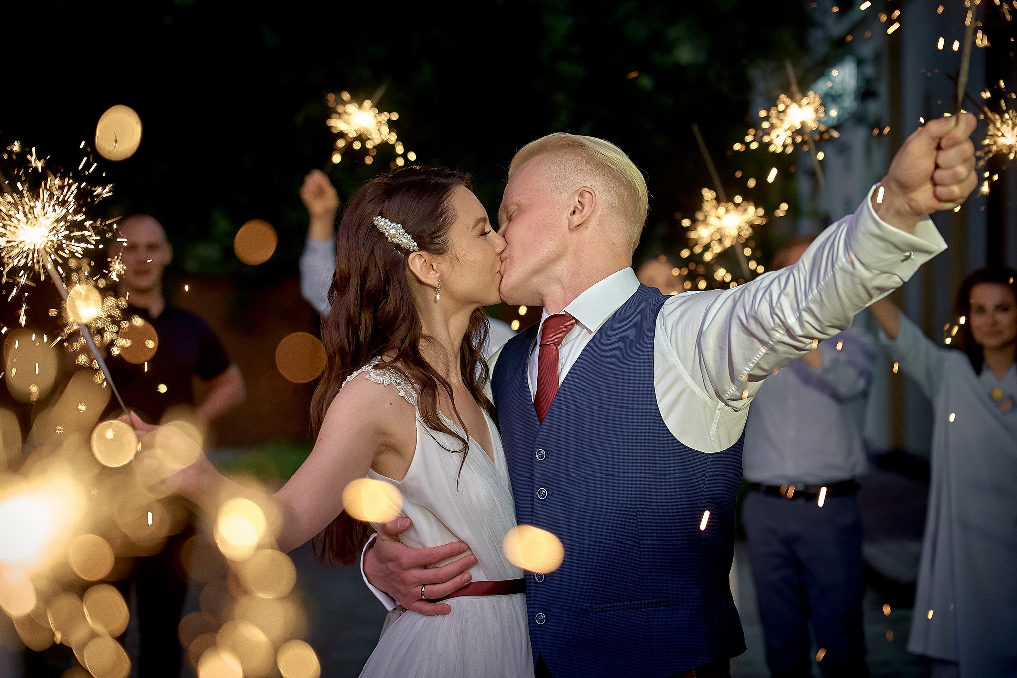 Молодожены целуются на фоне бенгальских огней. Невеста бросает букет подругам на свадебном банкете.  Свадебный фотограф на свадьбу в Москве Сергей Гаварос. gavaros.ru