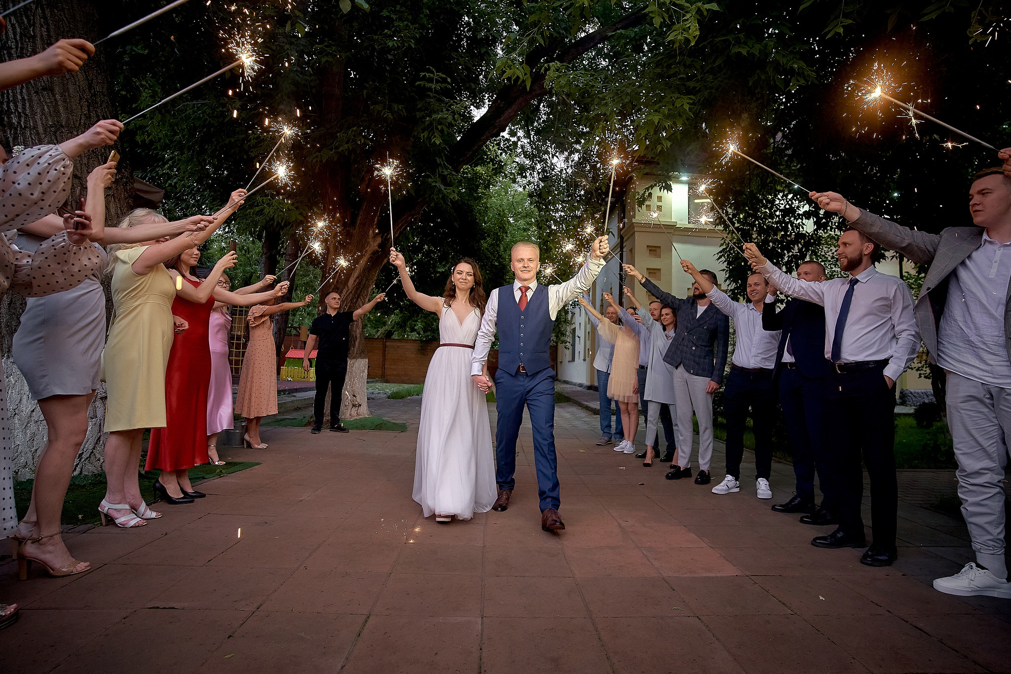 Гости и молодожены зажигают бенгальские огни Невеста бросает букет подругам на свадебном банкете.  Свадебный фотограф на свадьбу в Москве Сергей Гаварос. gavaros.ru