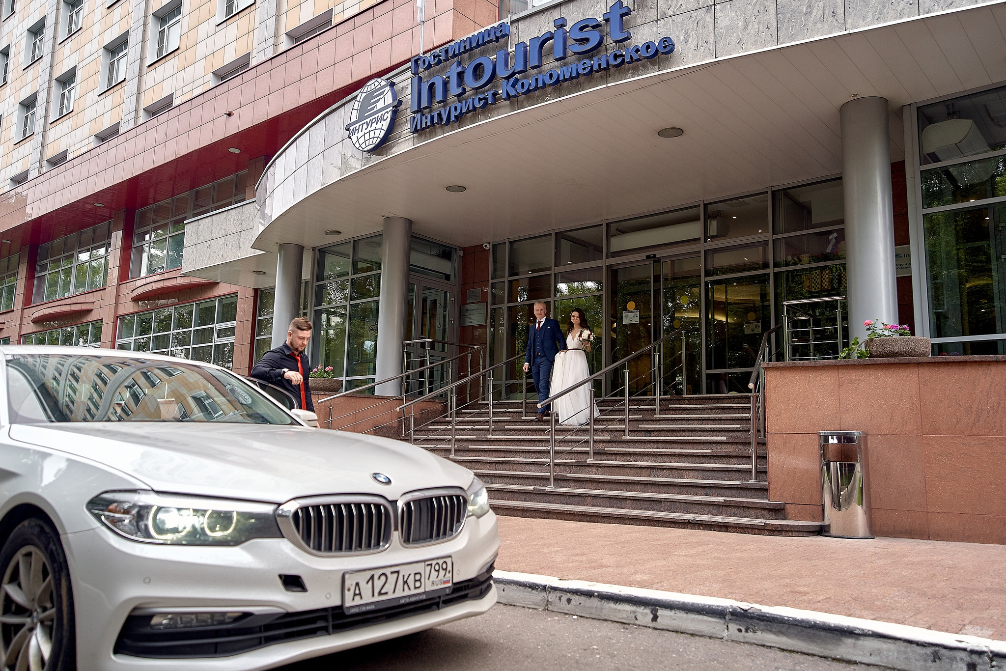 Выход невесты и жениха из отеля Встреча жениха и невесты. Жених с букетом смотрит на невесту - Отель Интурист Коломенское Фотограф на свадьбу в Москве Сергей Гаварос. gavaros.ru