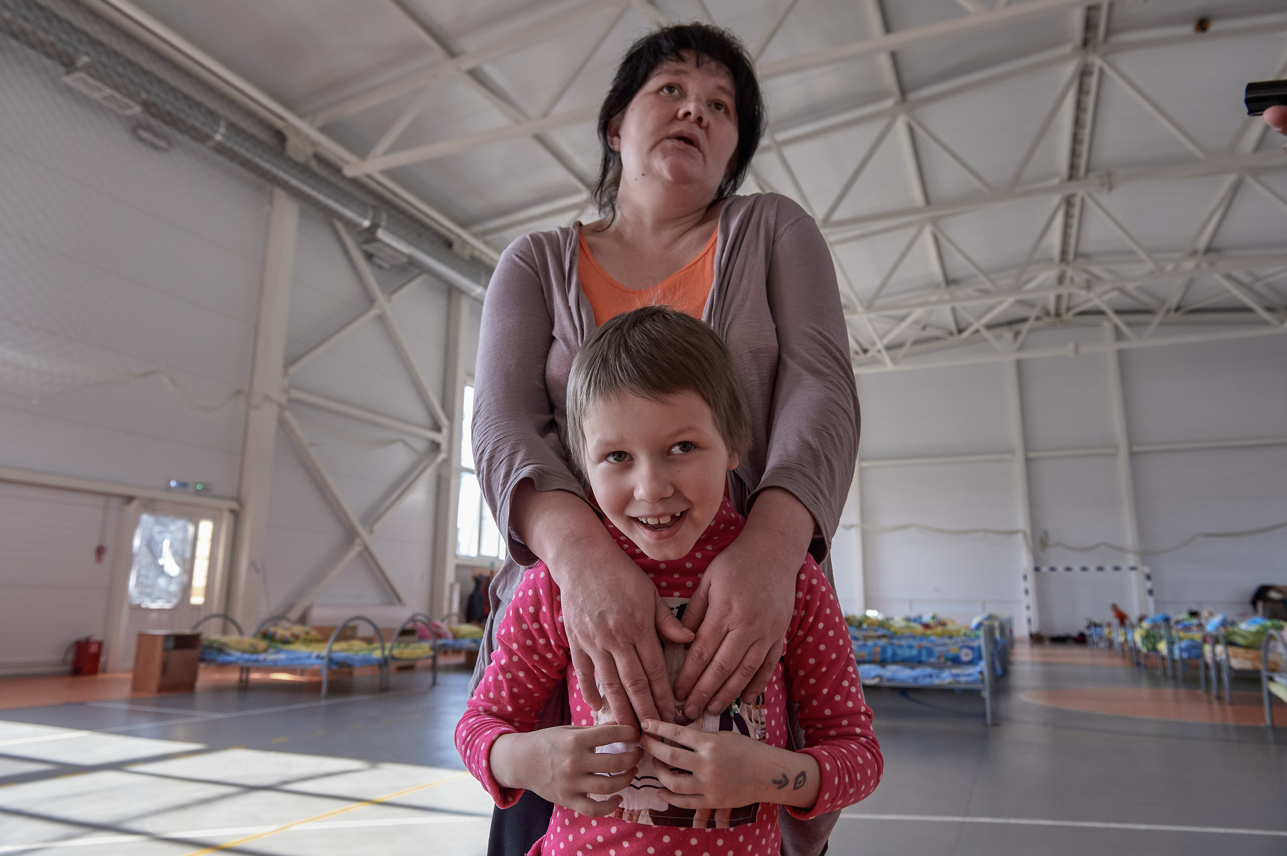 A mother of multiple children, Liliya Valiullina, with her daughter, originally from Uglegorsk, Donetsk region, evacuated to the Rostov region after intensified shelling, in a temporary refugee accommodation center set up in the sports hall of the rural cultural center in Lenin Hamlet, Rostov region, February 22, 2022.
