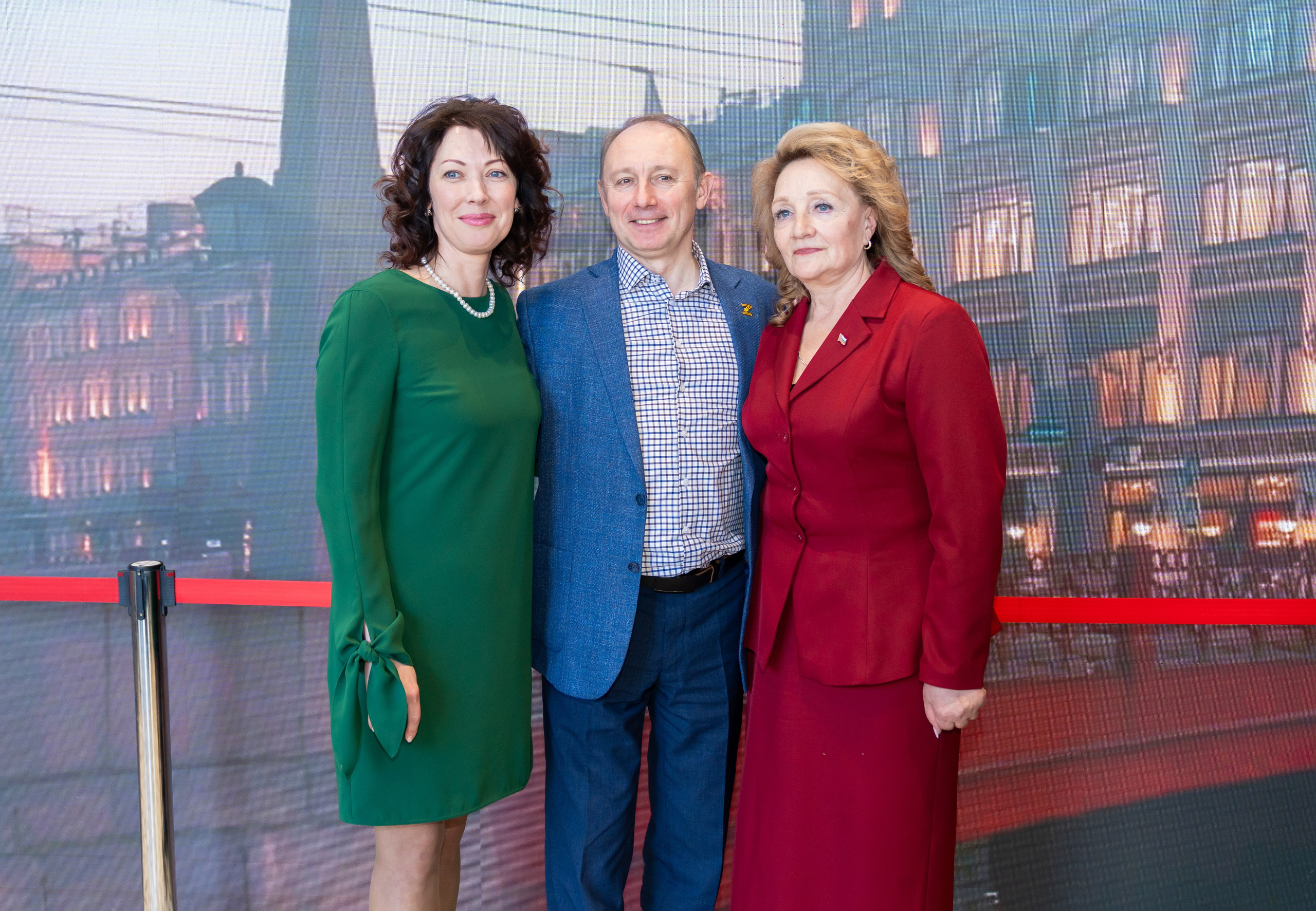 Три официальных лица на мероприятии Дня местного самоуправления: женщина в зелёном платье, мужчина в костюме и женщина в красном костюме. Центр Курёхина, Санкт-Петербург. Фото Евгения Мальцева.