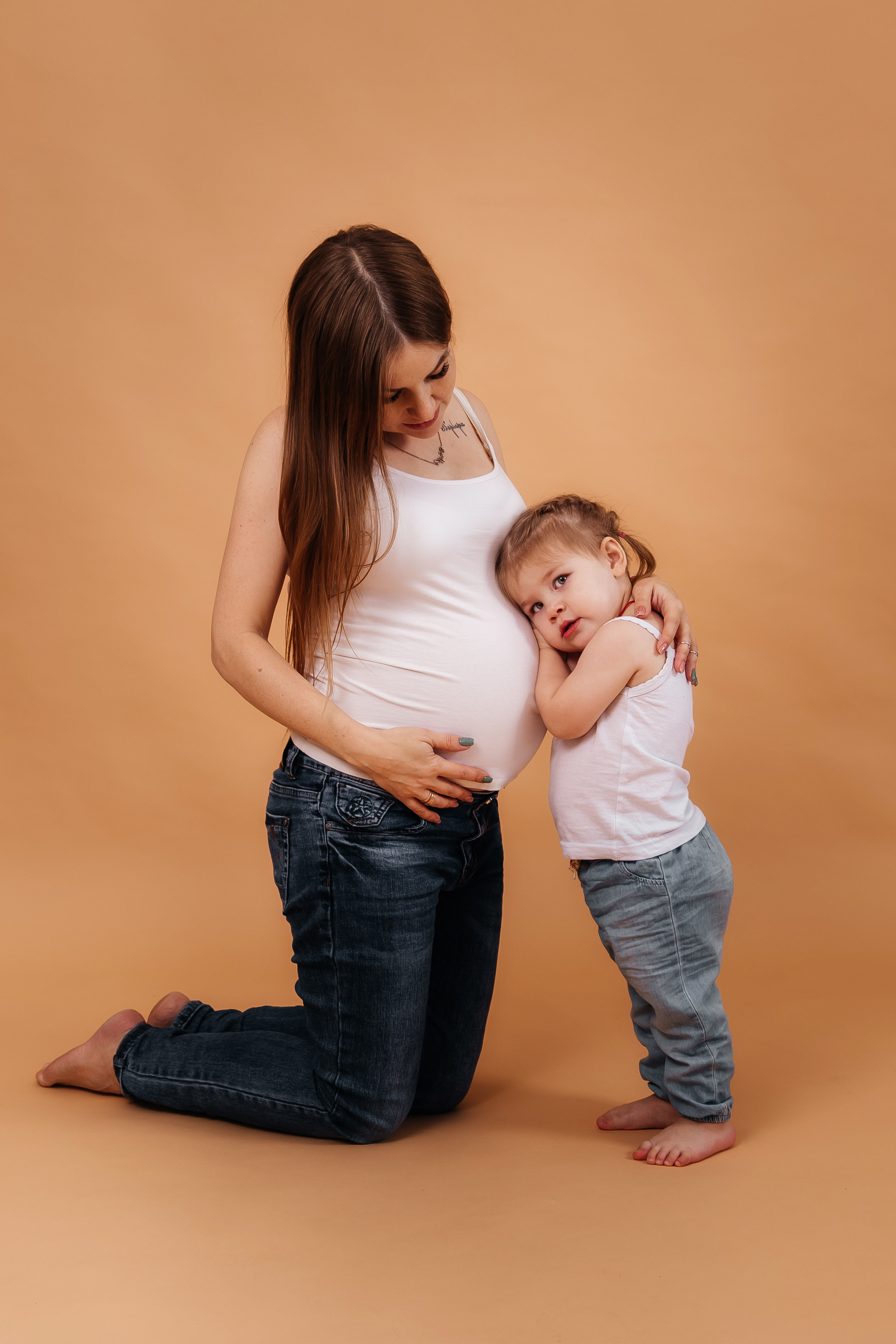 Беременная девушка  в джинсах  с ребенком