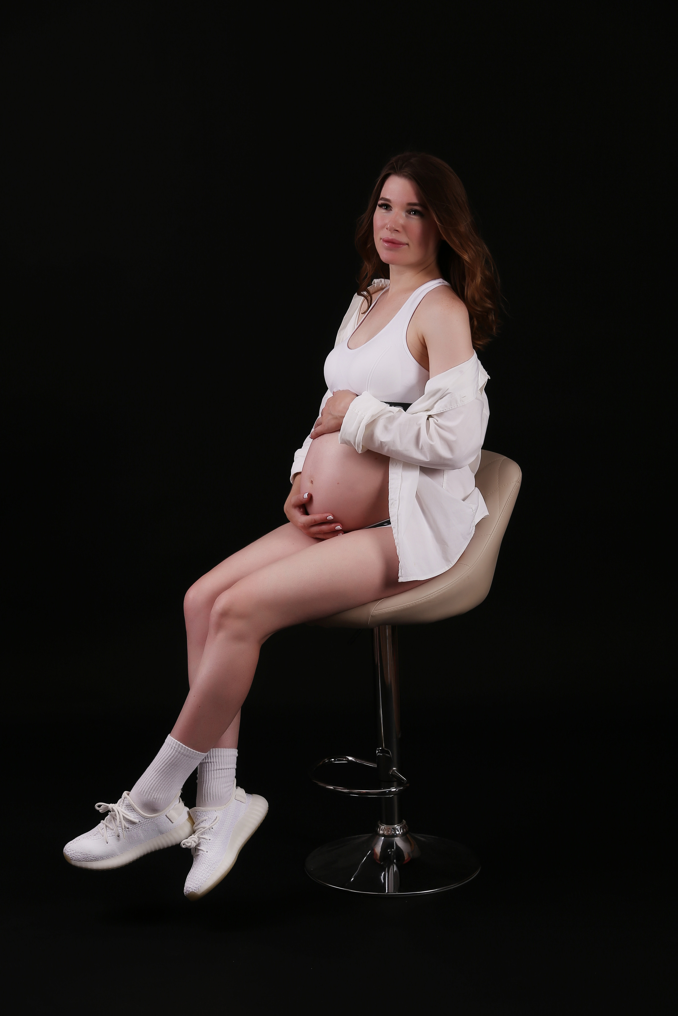 Беременная девушка  на темном фоне