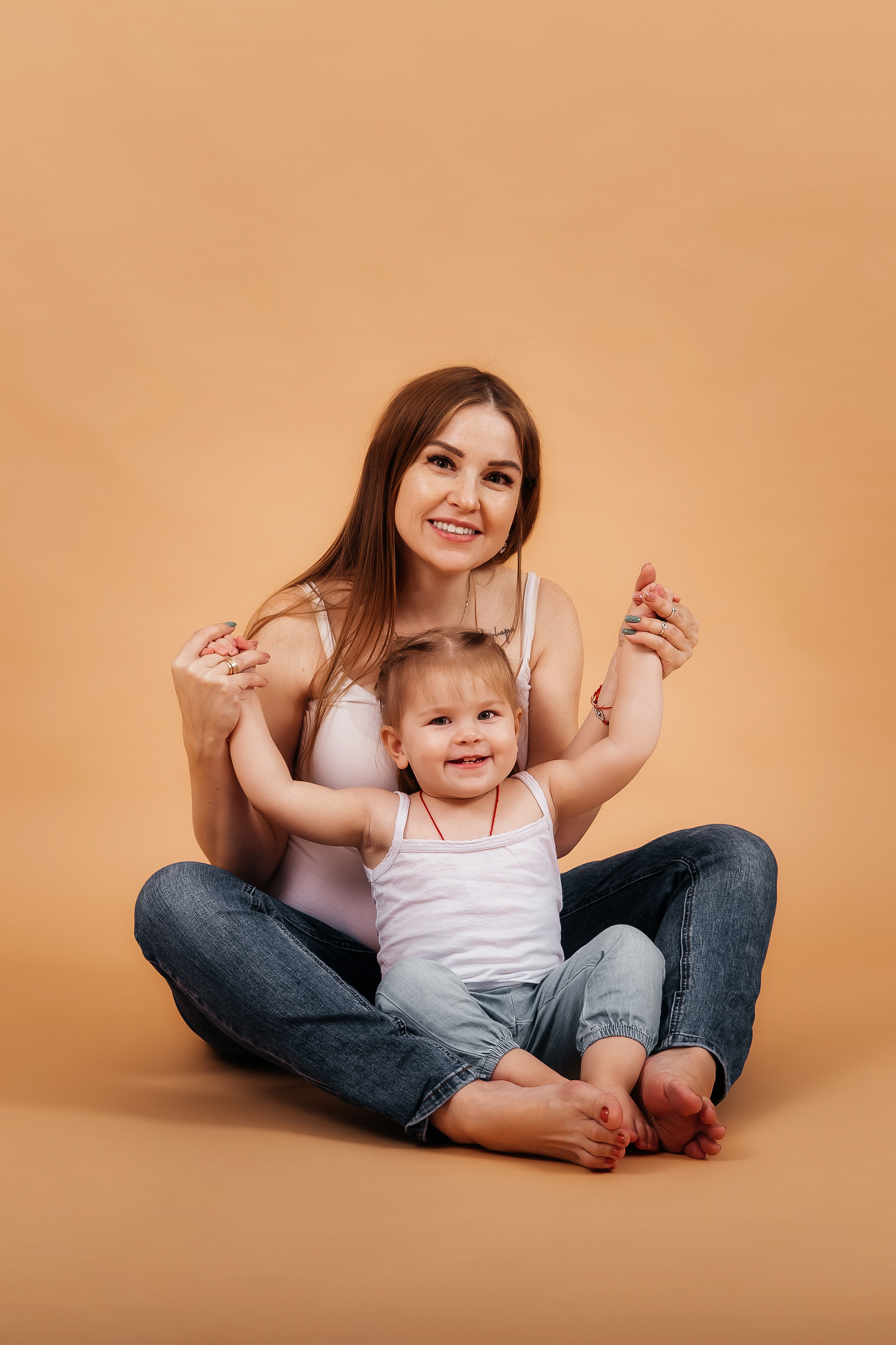 Беременная девушка  в джинсах смеются с ребенком