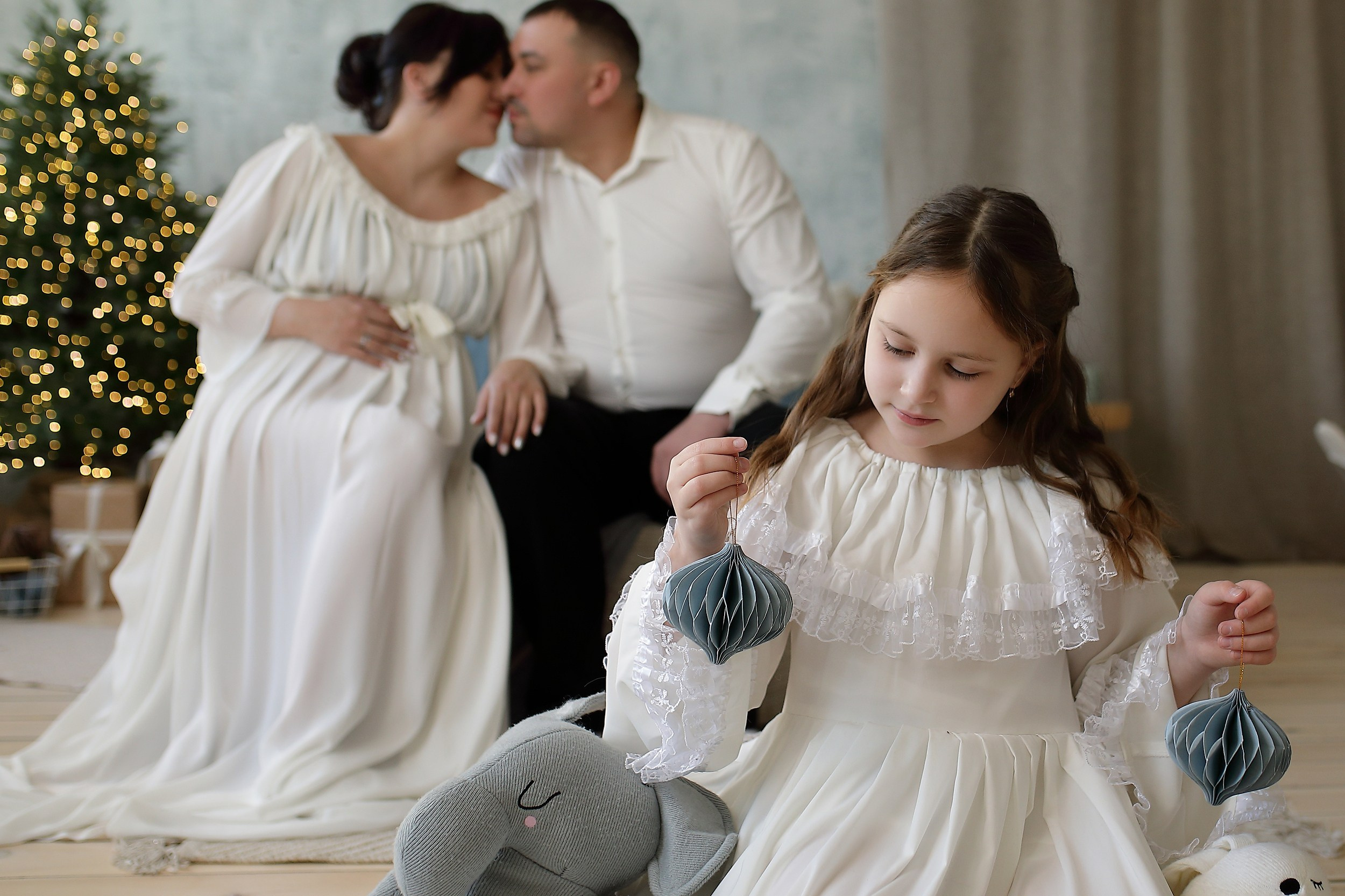 беременная женщина в черном платье на фоне ёлки