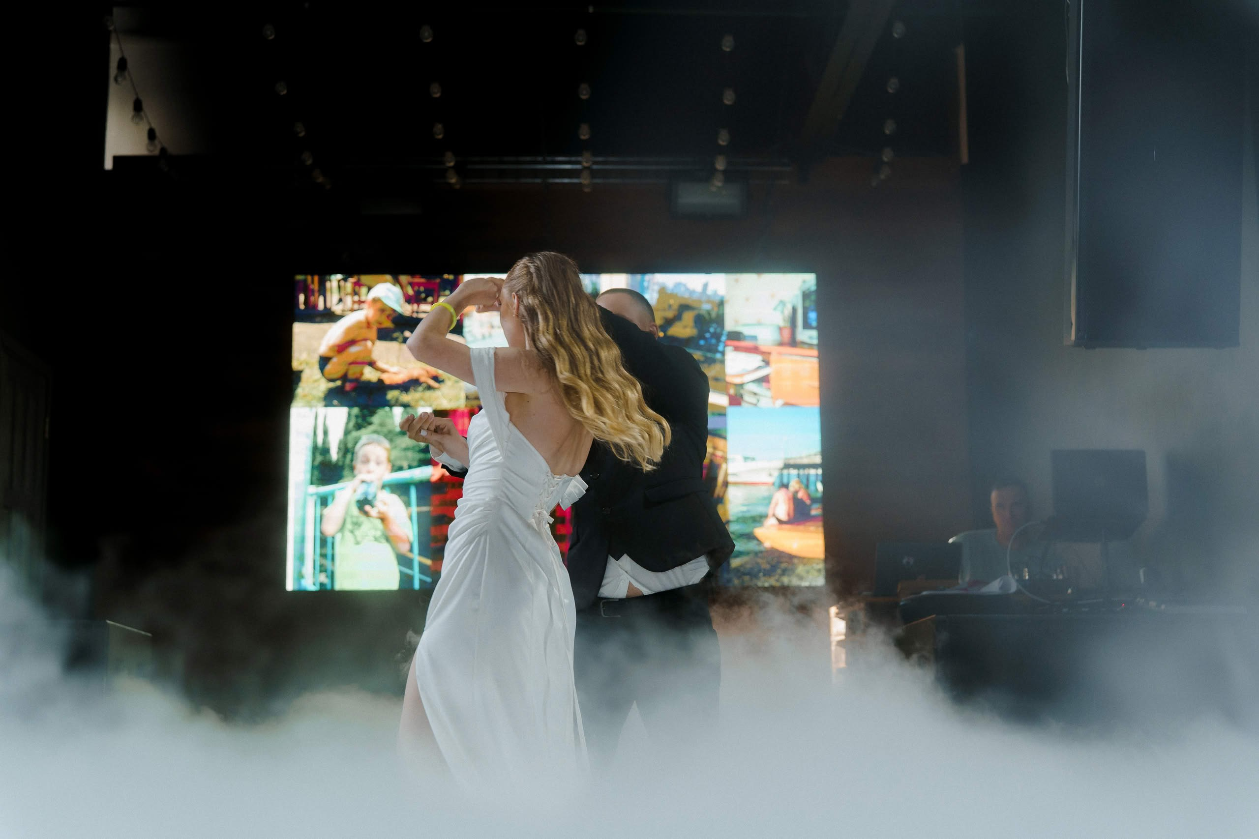 Невеста в белом платье и жених танцуют в облаках дыма в Event Rest