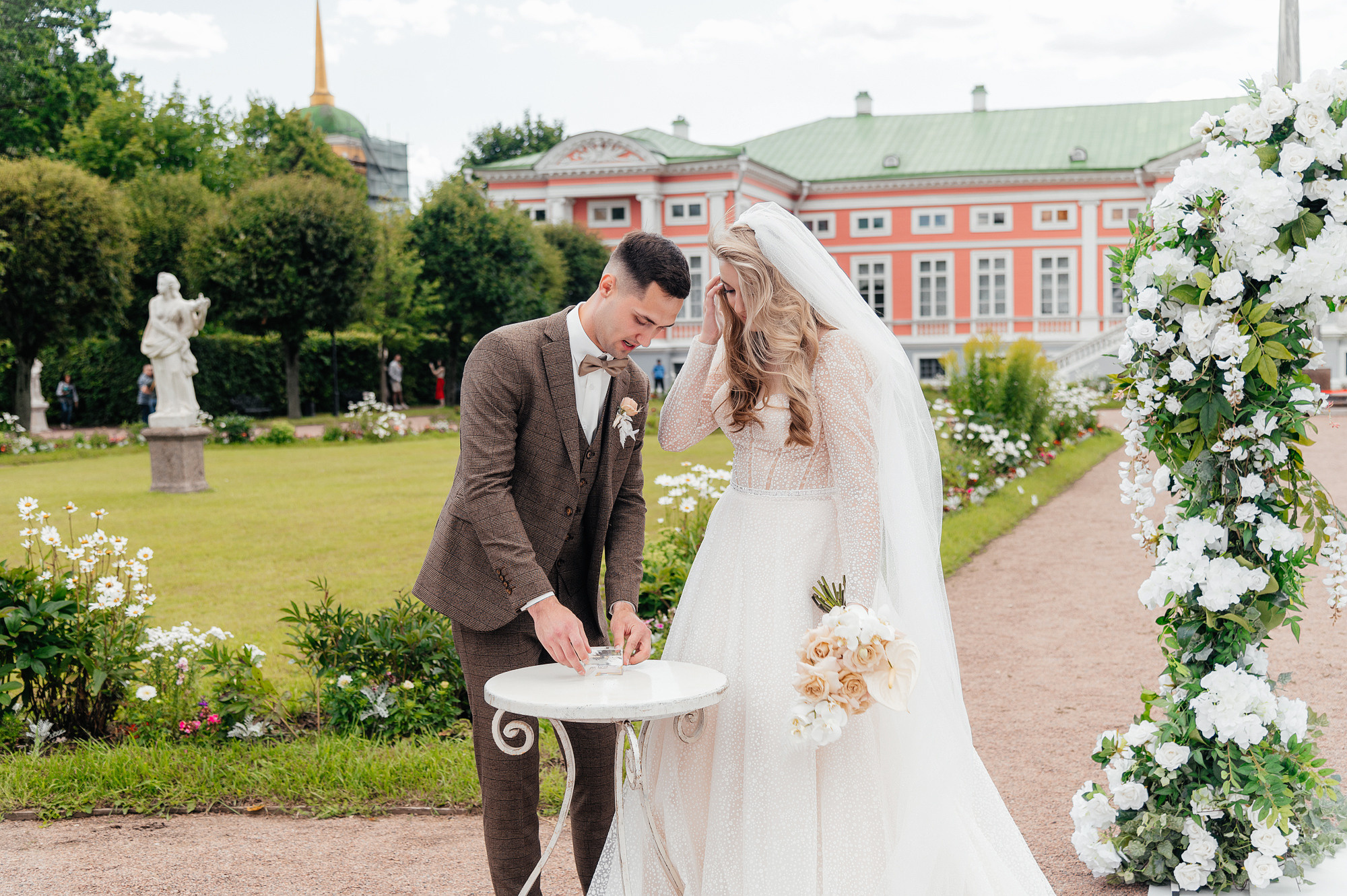 Молодожены обмениваются кольцами на выездной церемонии бракосочетания.