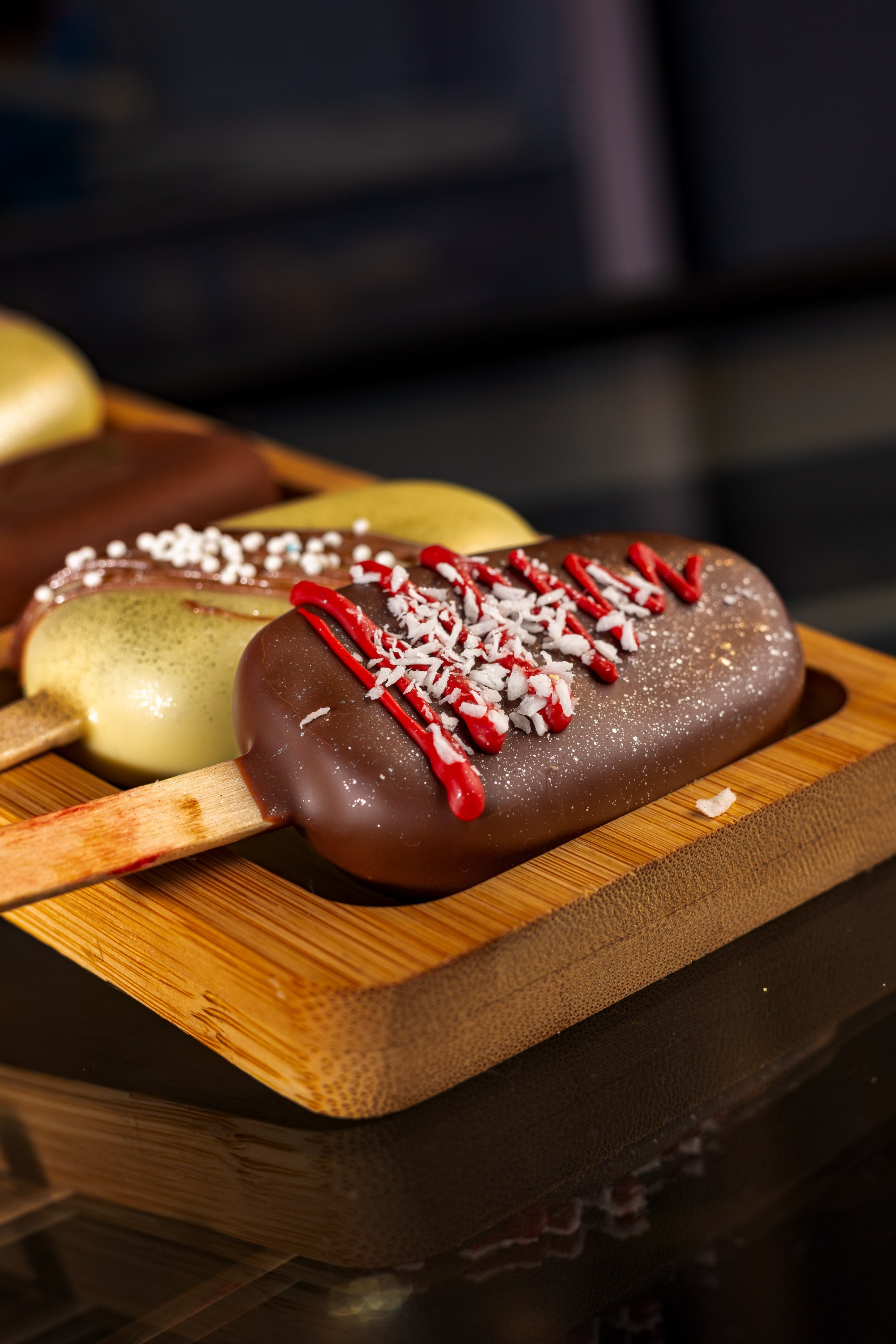 Десерт виде мороженого рекламную фотографию на тёмном фоне красный рисунок цветочек