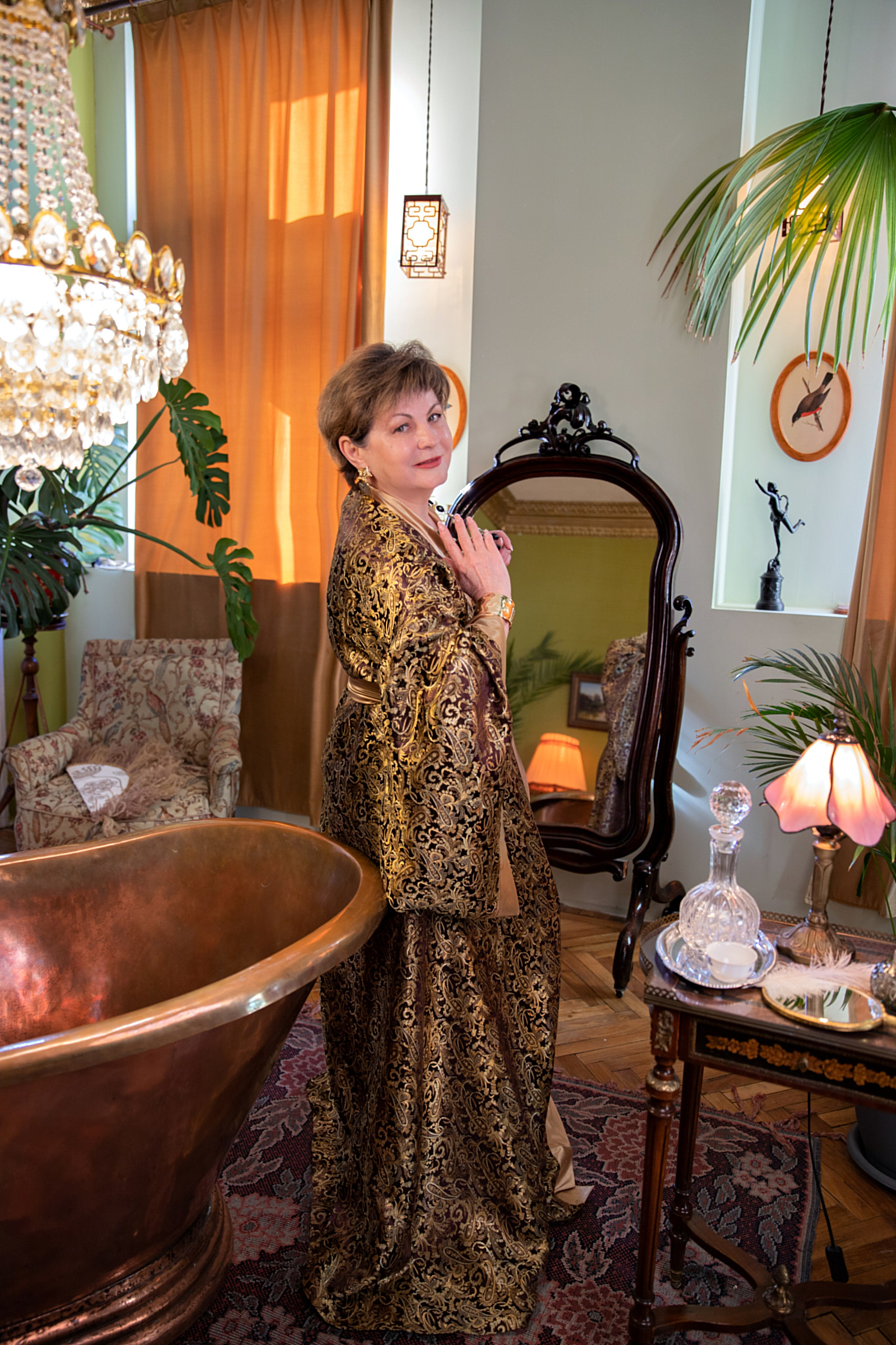 Женщина с изюминкой в пеньюаре, позирующая среди antique-декора в будуарном пространстве, демонстрируя свою элегантность и жизненную силу.т