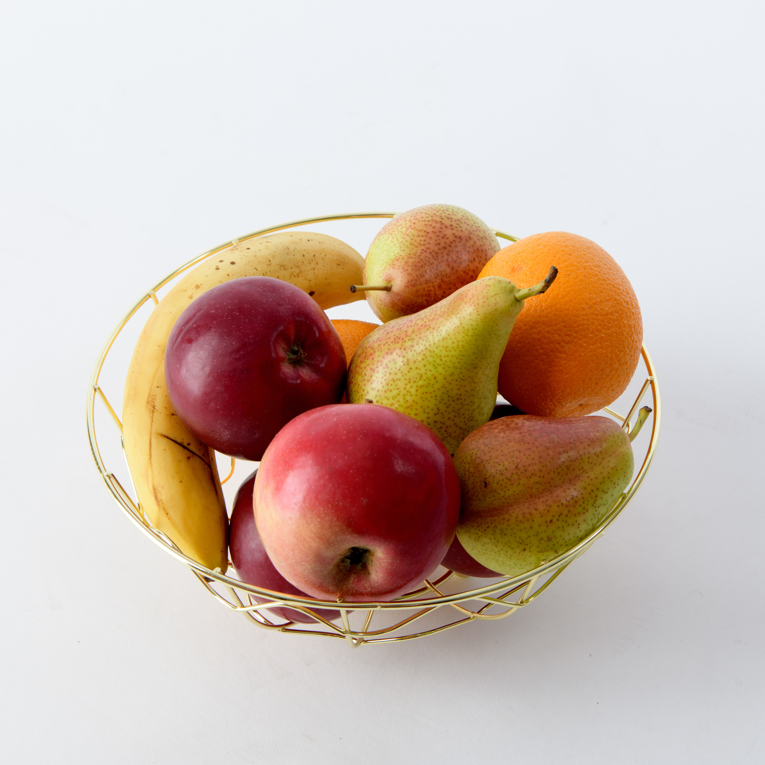 фрукты лежат в ажурной вазе из металла золотого цвета